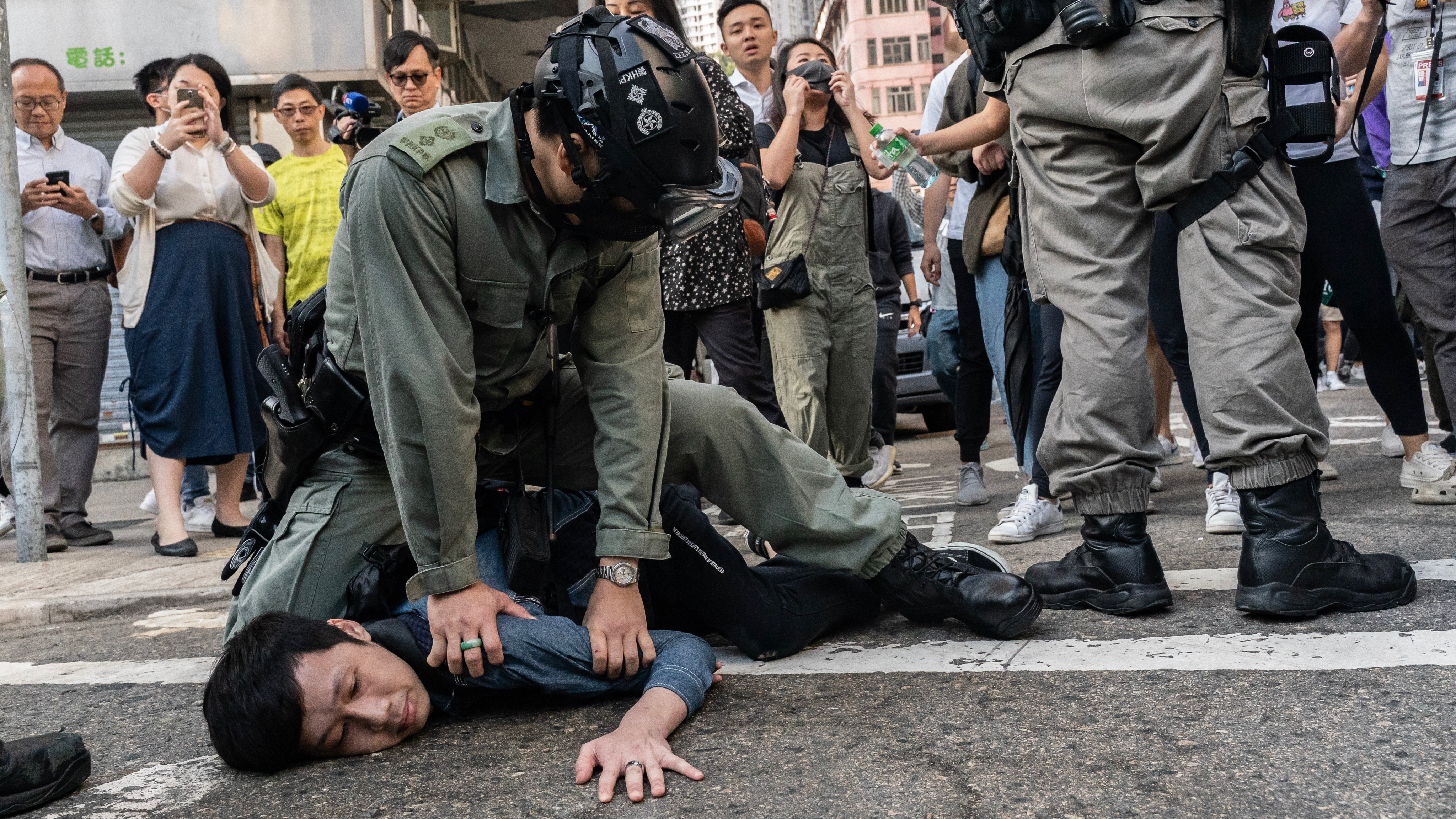 Riot police detain a pro-democracy protester in Hong Kong Monday. Anti-government protesters organized a general strike as their demonstrations stretched into a sixth month.