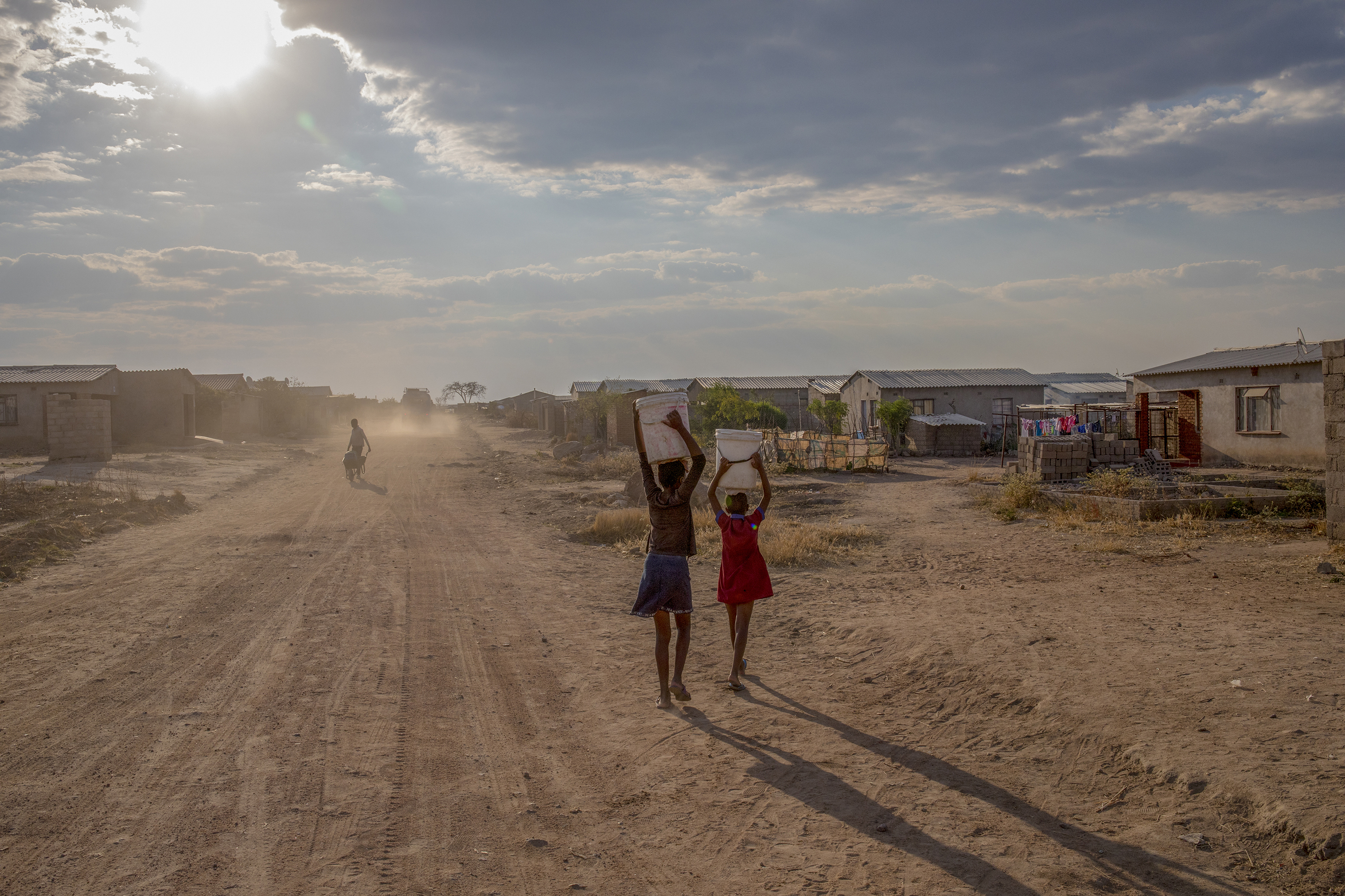 Girls carry containers of water filled from the local communal tap Zimbabwe, which is in the grip of a nationwide drought that has been linked to climate change. (Bloomberg/Getty Images)