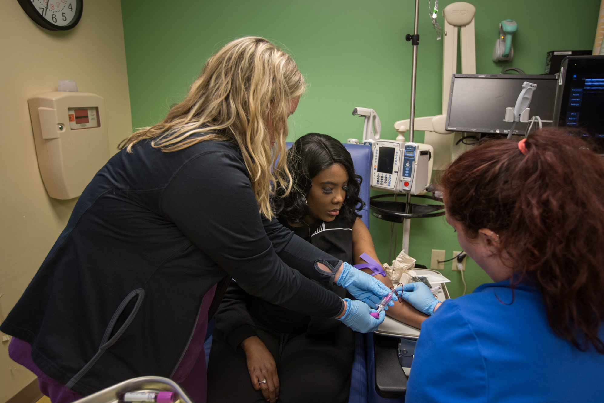 As part of a clinical trial to treat sickle cell disease, Victoria Gray (center) has vials of blood drawn by nurses Bonnie Carroll (left) and Kayla Jordan at TriStar Centennial Medical Center in Nashville, Tenn.