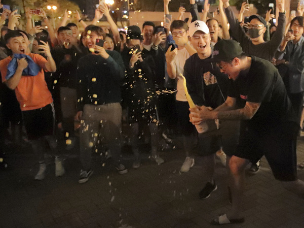 Pro-democracy supporters celebrate after pro-Beijing politician Junius Ho lost his election in Hong Kong, early Monday, Nov. 25, 2019.