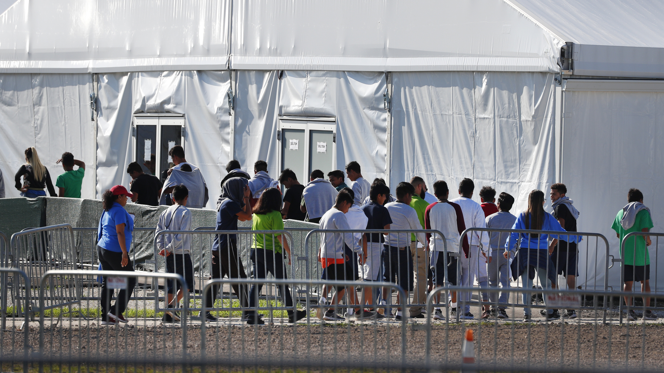 Migrant children line up to enter a tent at the Homestead Temporary Shelter for Unaccompanied Children in Homestead, Fla. in February 2019.