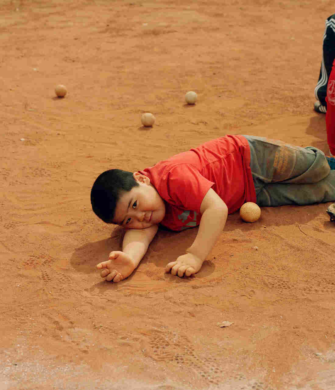 A boy lays on the baseball field