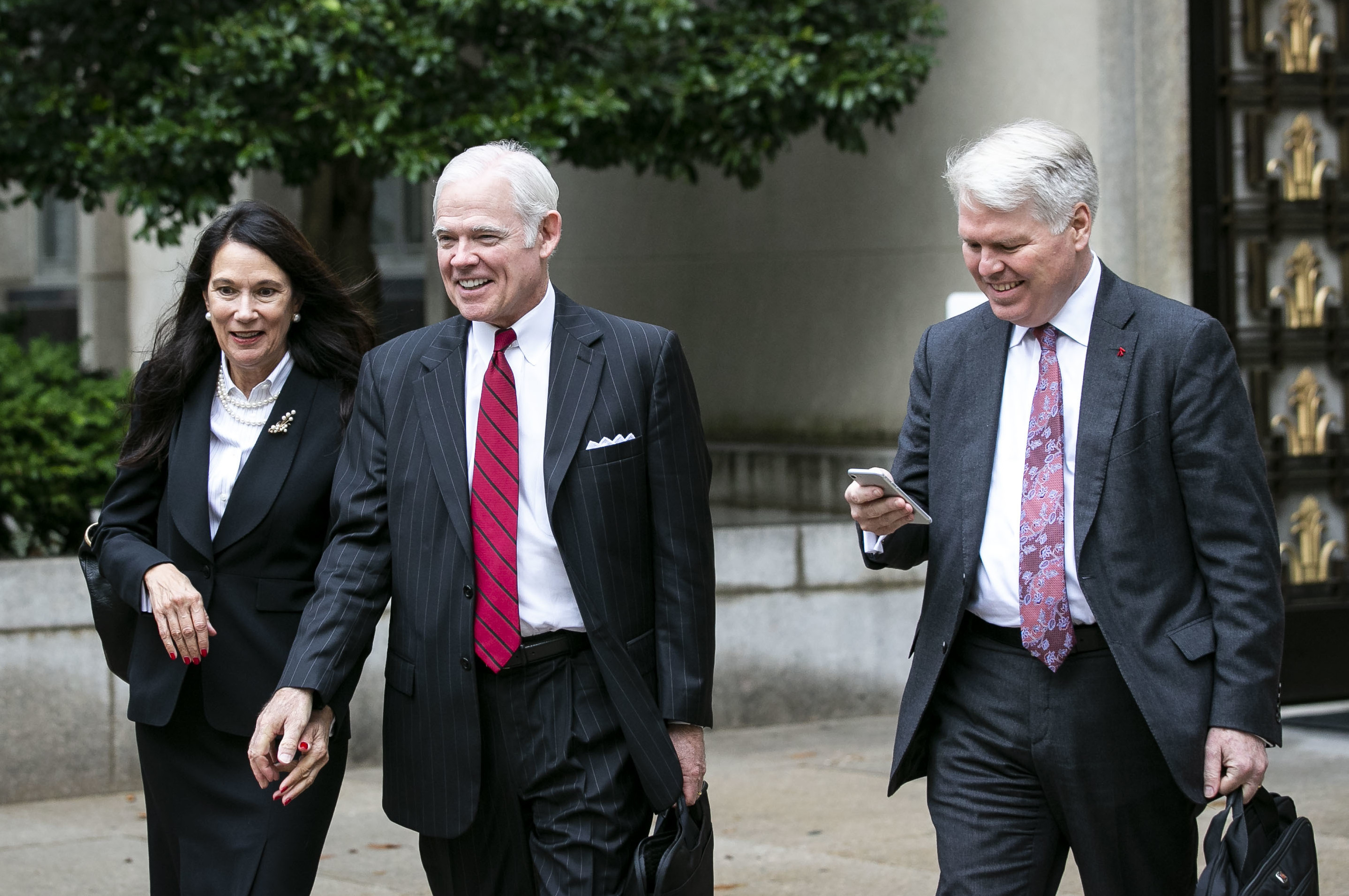 Attorney Charles Cooper, representing former national security aide Charles Kupperman (center) departs federal court in Washington in October. On Tuesday, Cooper asked a federal court to keep alive a lawsuit centered on a now-withdrawn subpoena filed by House Democrats that sought Kupperman's testimony as part of the impeachment inquiry. (Bloomberg via Getty Images)