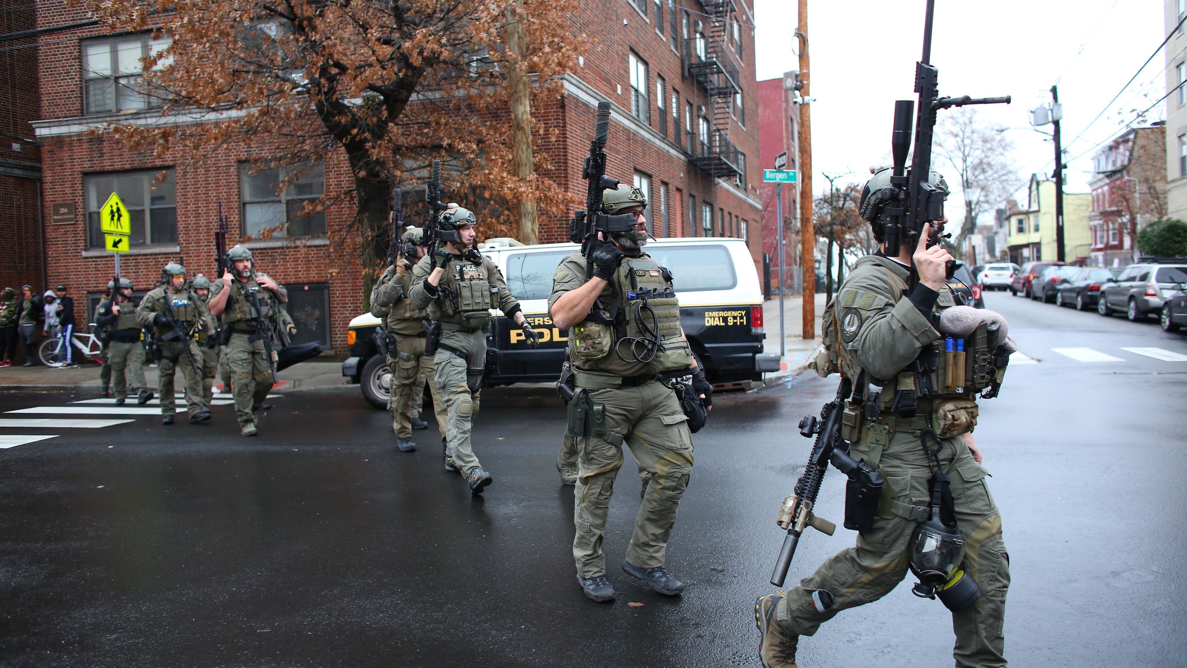 Police arrive at the scene of a shooting in Jersey City, N.J., Tuesday. There were two separate shooting incidents beginning at Bayview Cemetery and then later at a kosher market. (AFP via Getty Images)