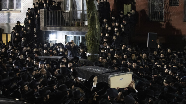 Orthodox Jewish men carry Moshe Deutsch's casket outside a Brooklyn synagogue following his funeral Wednesday in the Williamsburg neighborhood of Brooklyn. Deutsch was among three civilians killed in the shooting at a kosher market Tuesday in neighboring Jersey City, N.J.