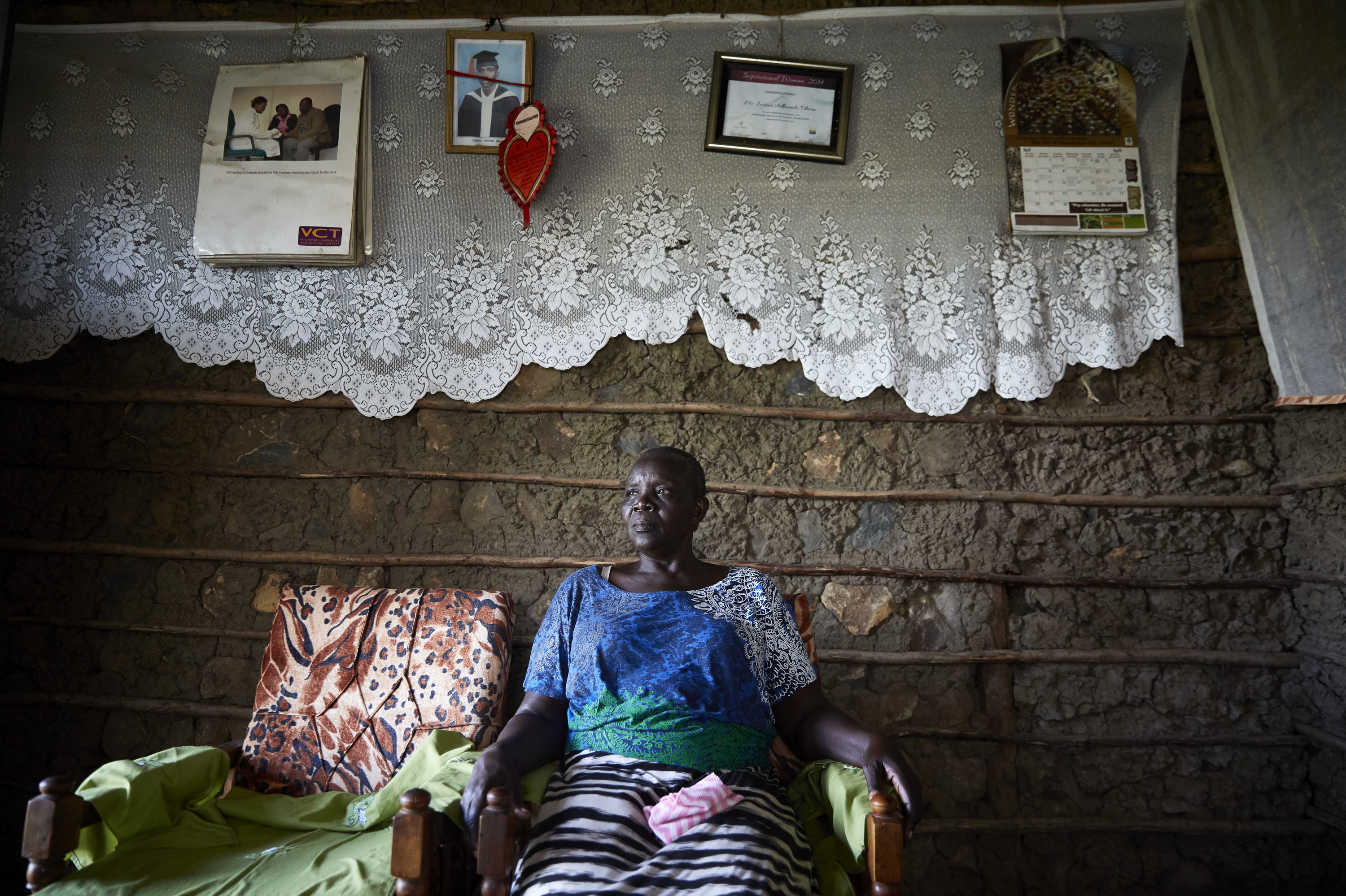 Justine Adhiambo Obura in her living room at Nduru Beach. A framed certificate naming her "Inspirational Woman of the Year 2014" hangs on the wall.