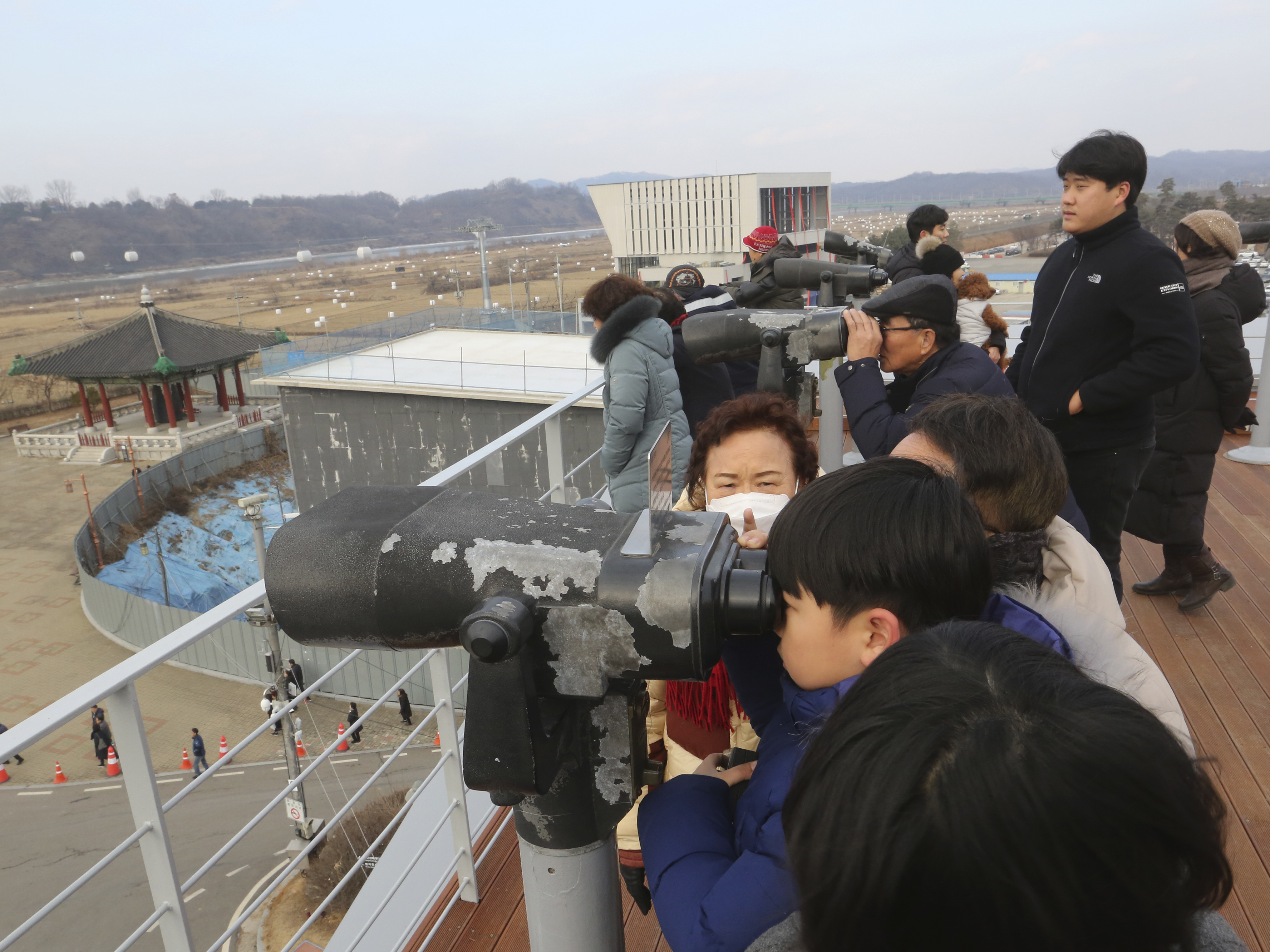Visitors celebrating the New Year use binoculars to watch North Korean territory Wednesday, near the border between North and South Korea.
