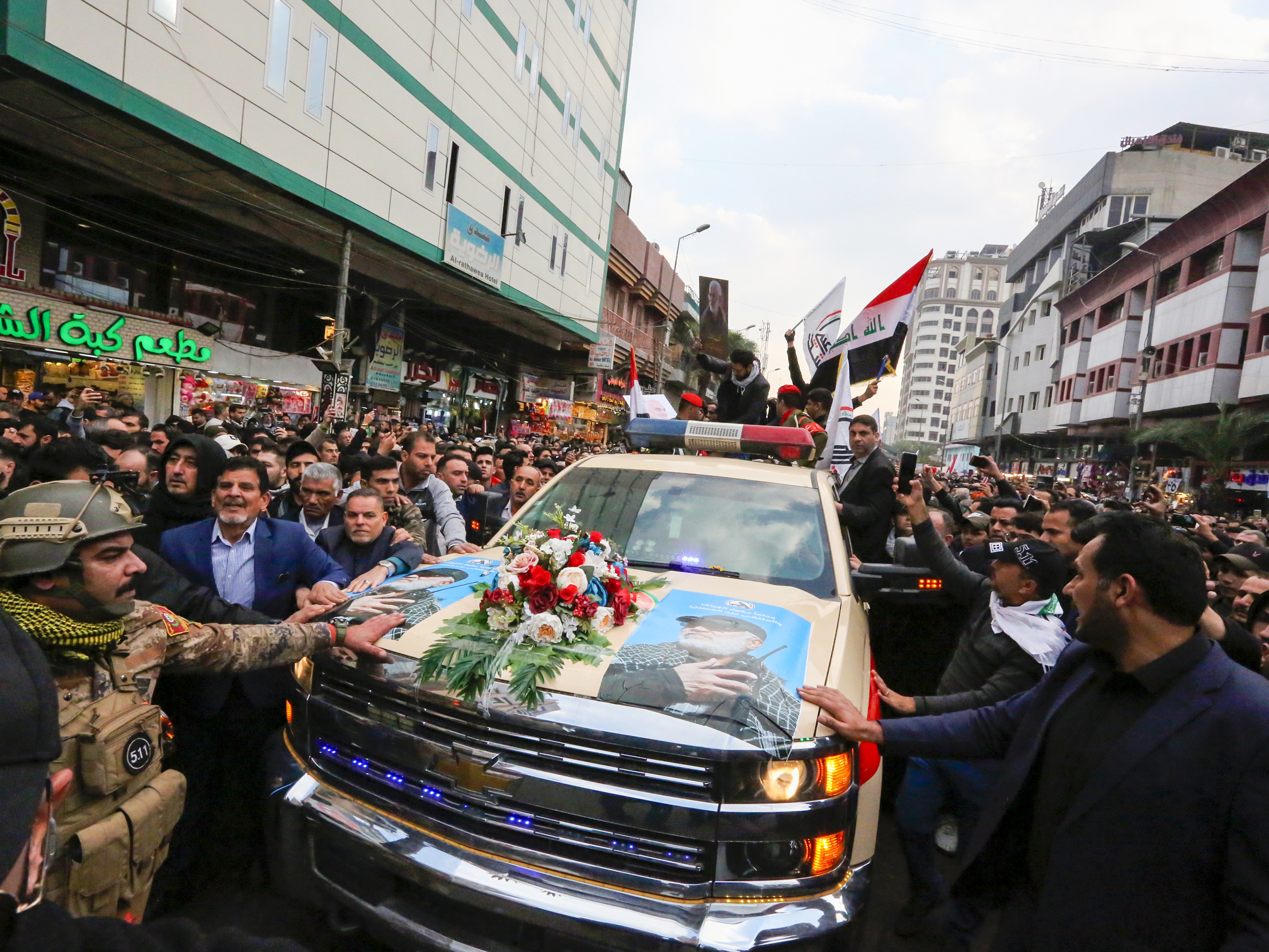Mourners surround a vehicle carrying the coffins of Iranian Maj. Gen. Qassem Soleimani and Iraqi militia leader Abu Mahdi al-Muhandis, during a funeral procession Saturday in Baghdad. (AFP via Getty Images)