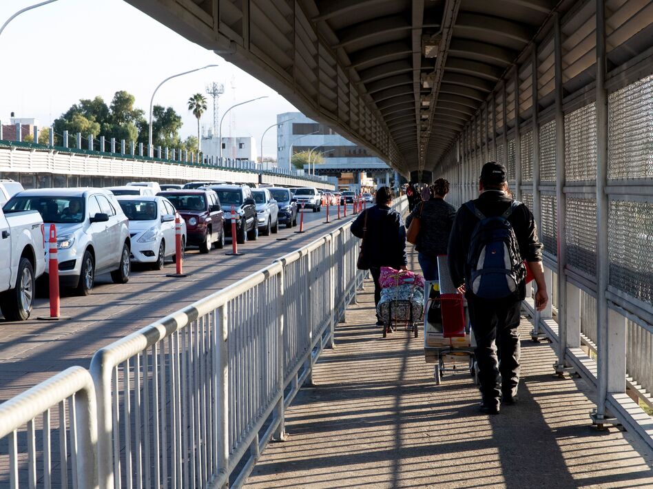 People walk and drive across a bridge on the U.S.-Mexico border in Laredo, Texas. Thousands of people cross back and forth every day, in cars or on foot. (Suzanne Cordeiro/AFP via Getty Images)