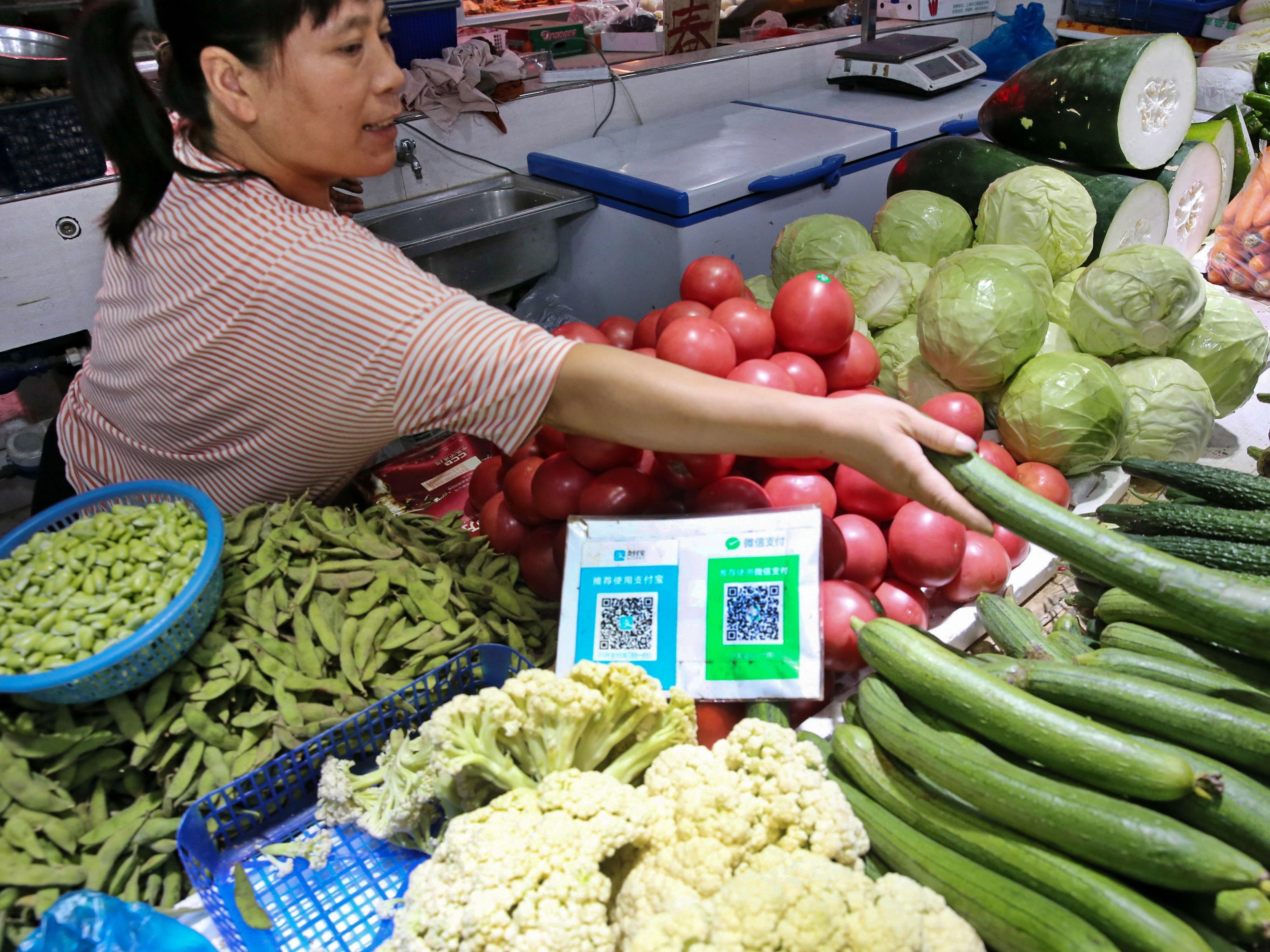 Alipay and WeChat QR codes for online payment are displayed at a vegetable stall in Nantong in China's eastern Jiangsu province. Now China's central bank is preparing to test a digital currency. (AFP via Getty Images)