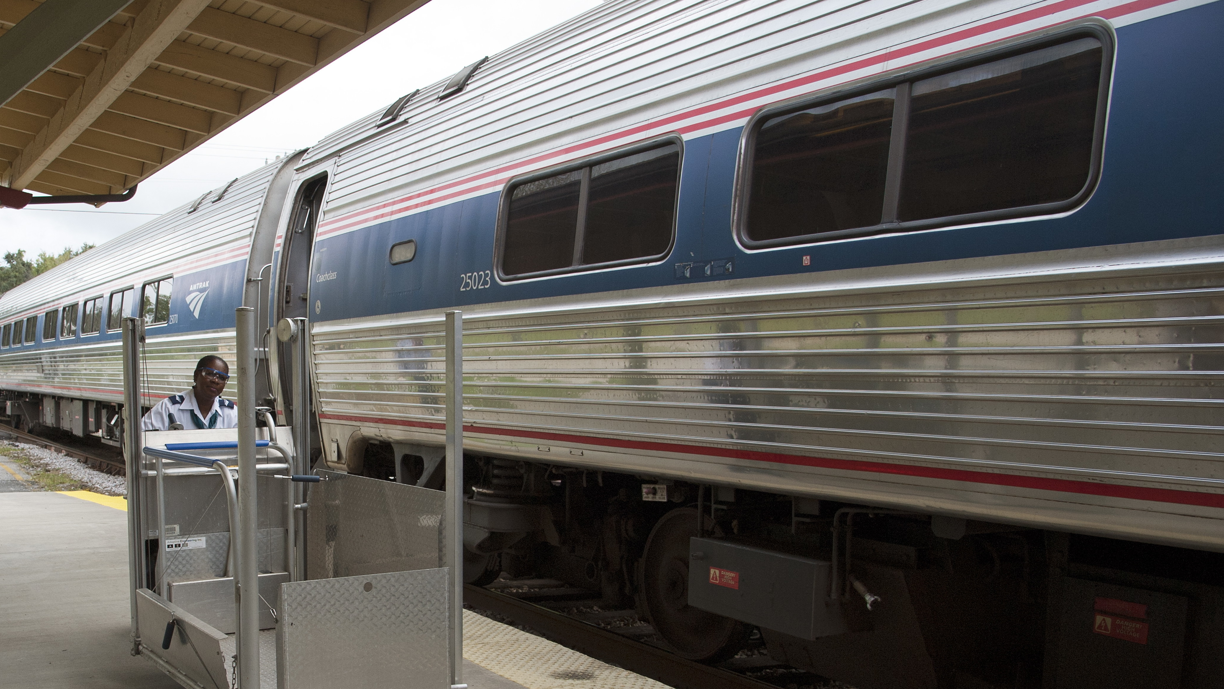 A member of the station staff pushes a portable wheelchair lift along the platform at an Amtrak station in DeLand, Fla. The company says its policies for having to adjust or remove seats has changed. (Universal Images Group via Getty Images)