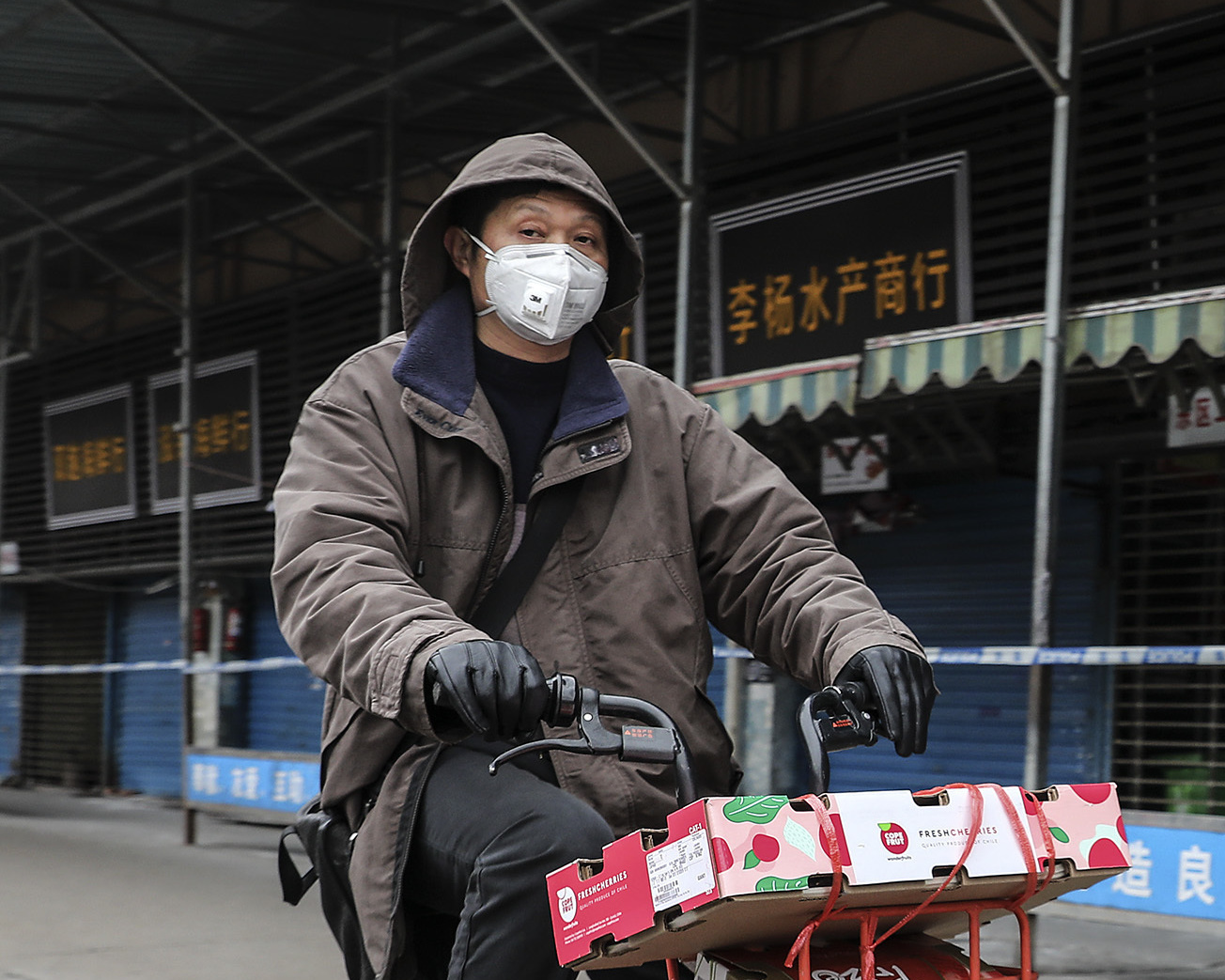A man rides past the Huanan Seafood Wholesale Market in Wuhan, China, which was closed after being linked to cases of a newly discovered coronavirus. (Getty Images)