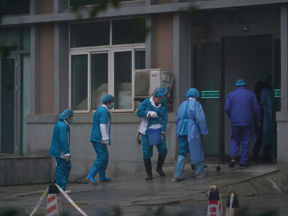 Hospital staff wash the emergency entrance of Wuhan Medical Treatment Center, where patients infected with a new virus are being treated, in Wuhan, China, on Wednesday. (Dake Kang/AP)