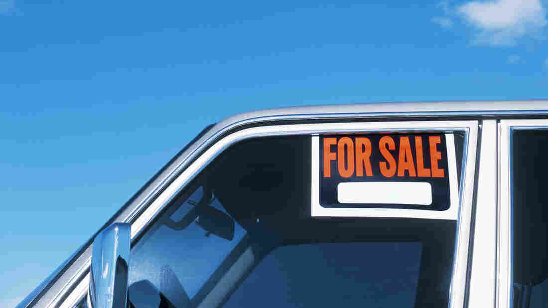 A For Sale sign is displayed on the window of a car.