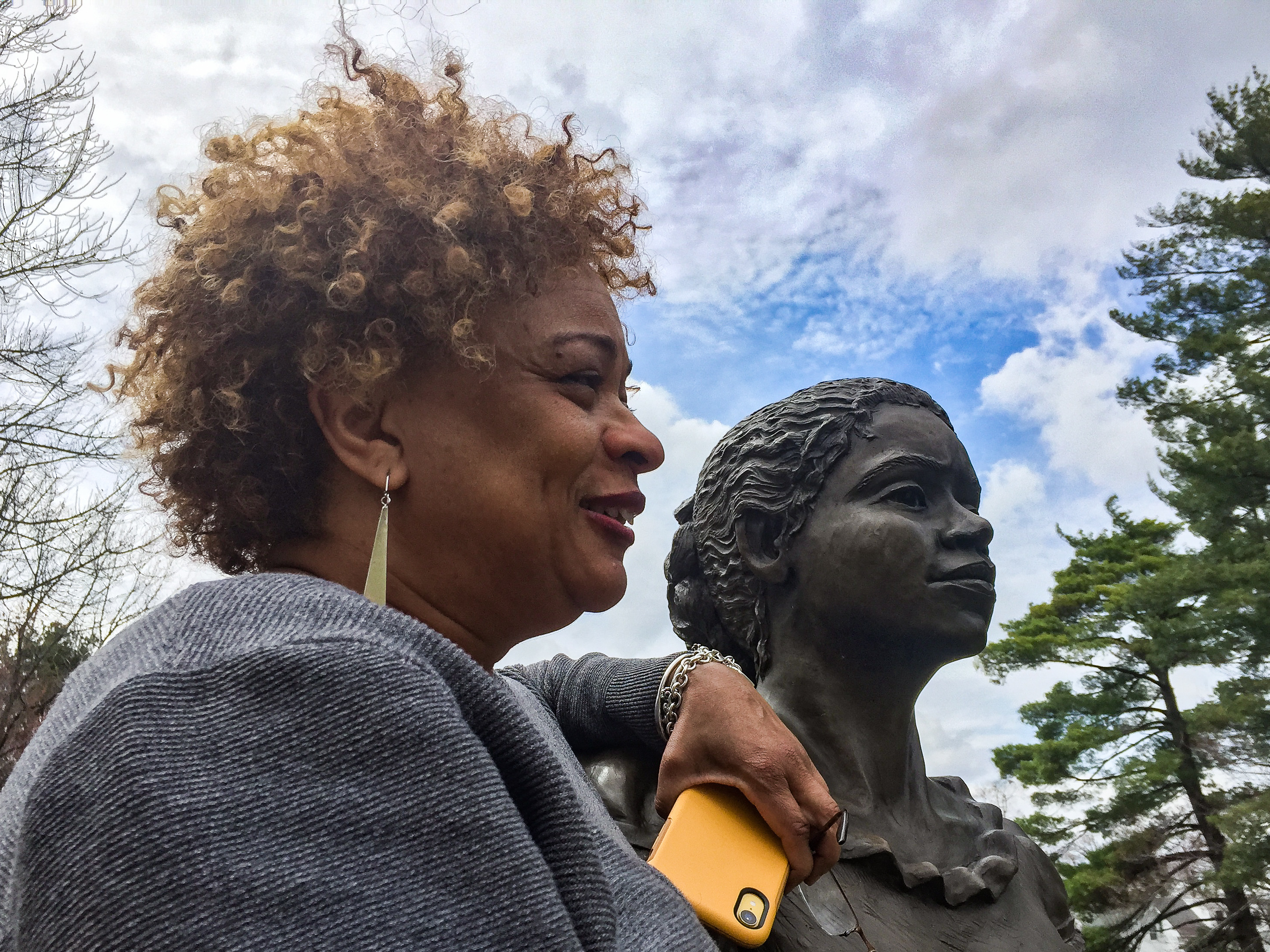 JerriAnne Boggis, executive director of the Black Heritage Trail of New Hampshire, poses with a monument that was erected in Harriet E. Wilson's honor. Boggis says when she read Wilson's book, she felt as if it was written the book just for her. (New Hampshire Public Radio)