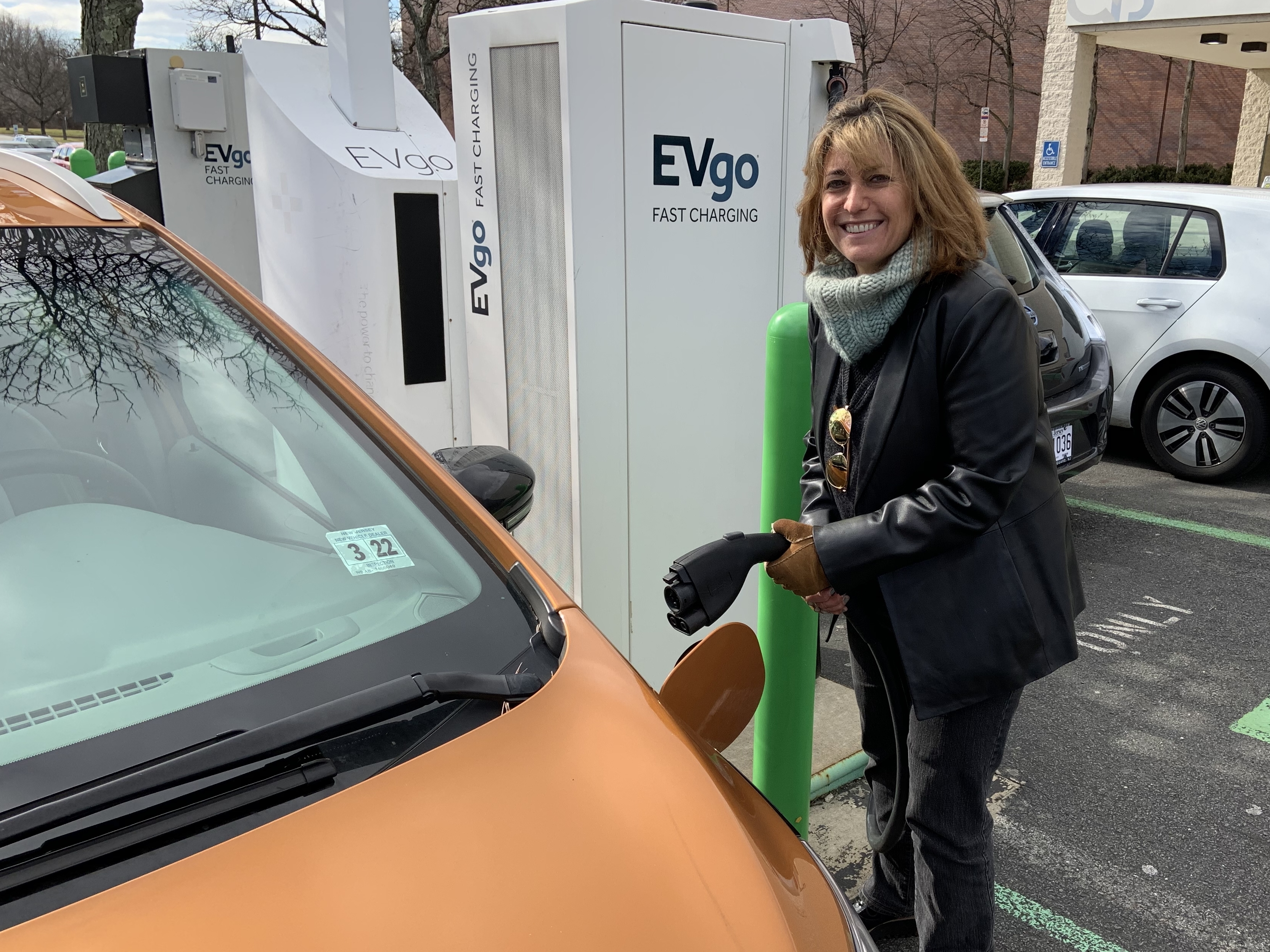 Pam Frank, CEO of ChargEVC, drives a bright Orange Chevrolet Bolt because she wants others to notice its an electric car. (NPR)