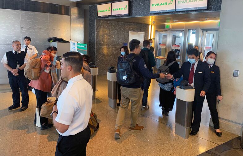 Humans — workers and flight crews as well as passengers — can be exposed to any number of pathogens at airports. EVA Air employees are seen wearing face masks at the Los Angeles airport in February amid the coronavirus outbreak. U.S. officials advise masks are not the best way to mitigate one's risk of contracting the virus. (Daniel Slim/AFP via Getty Images)