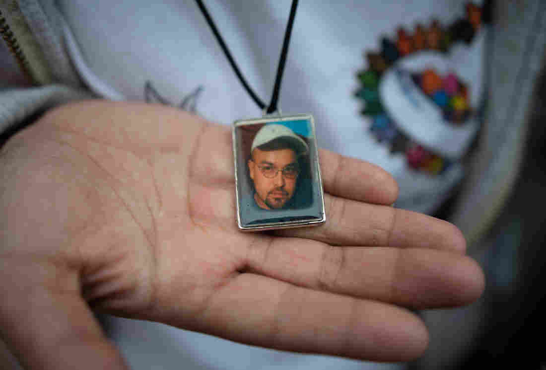 A woman shows a pendant with a portrait of Gustavo Trujillo, who disappeared in 2010 in Poza Rica, Veracruz, Mexico.