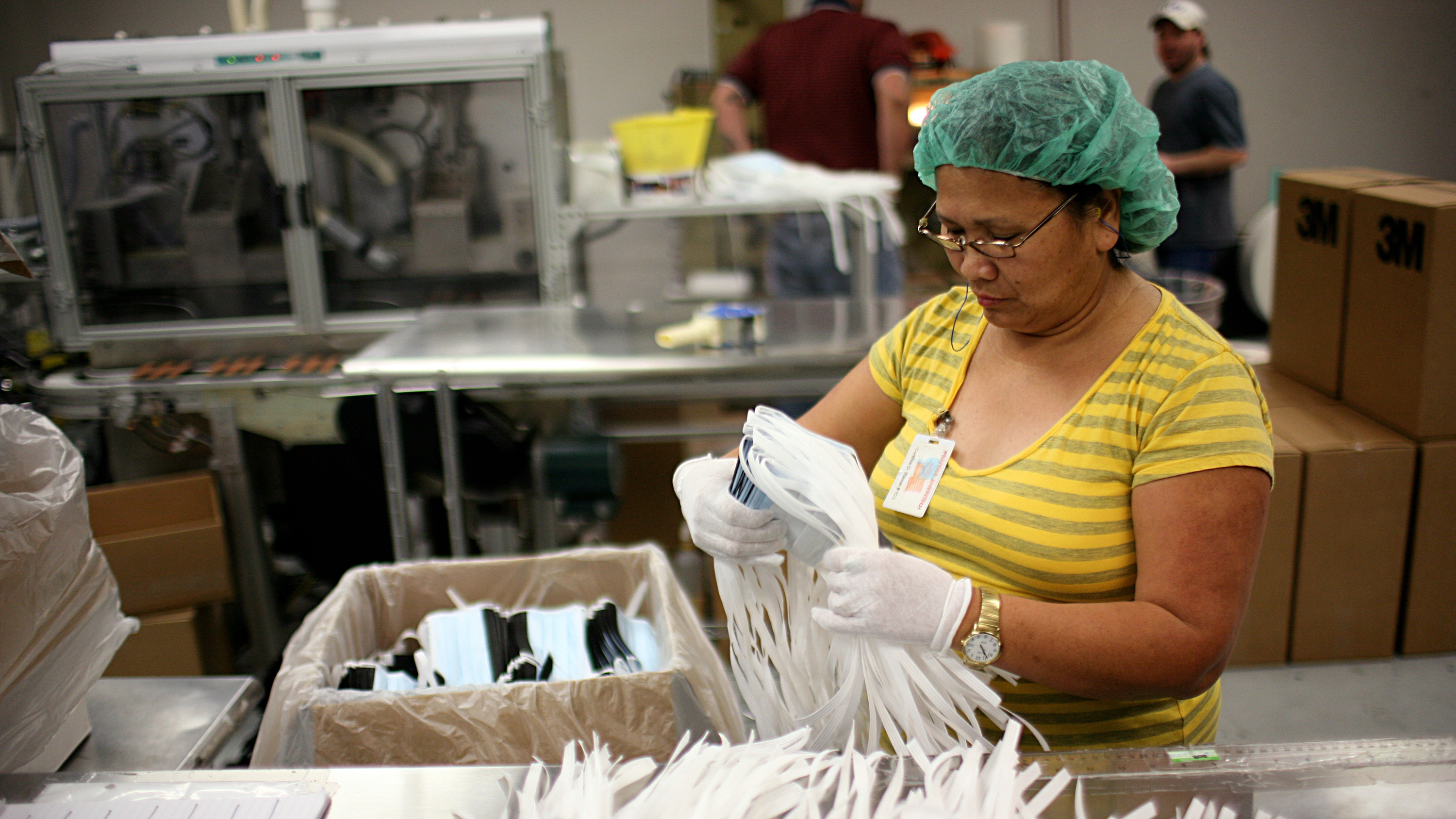 A Prestige Ameritech employee inspects disposable surgical masks May 3, 2009, at the company