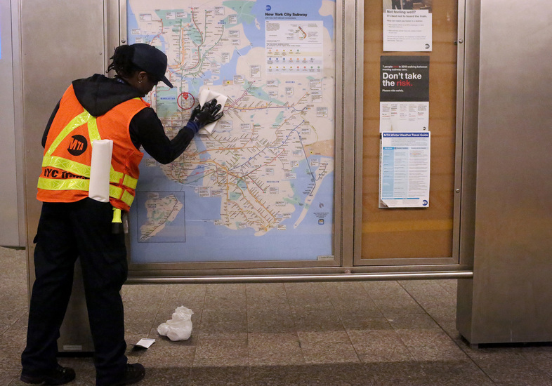 A metro transit authority cleaning staff member disinfects the 86th St. Q train station in New York City. (Yana Paskova/Getty Images)