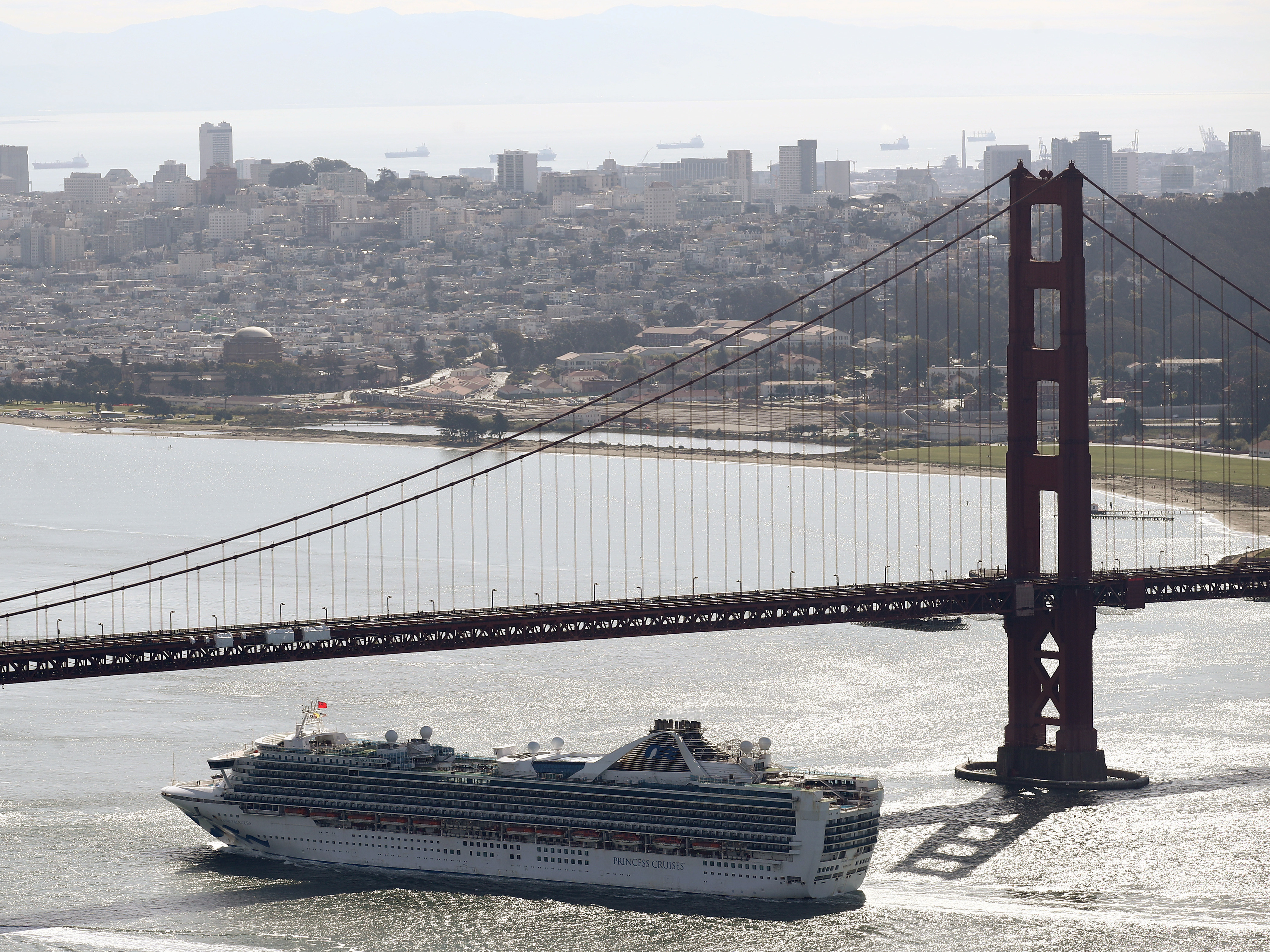 The Grand Princess cruise ship heads under the Golden Gate Bridge to a port in Oakland, Calif., on Monday. The ship's more than 2,400 passengers are headed to either medical care or a quarantine due to the coronavirus. (Getty Images)