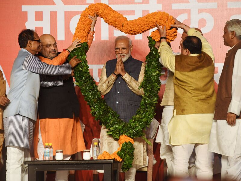 Indian Prime Minister Narendra Modi as he is draped by the Bharatiya Janta Party (BJP) president Amit Shah and other senior leaders as they celebrate Modi's victory on May 23, 2019. Prime Minister Narendra Modi vowed an "inclusive" future for all Indians after a landslide election.