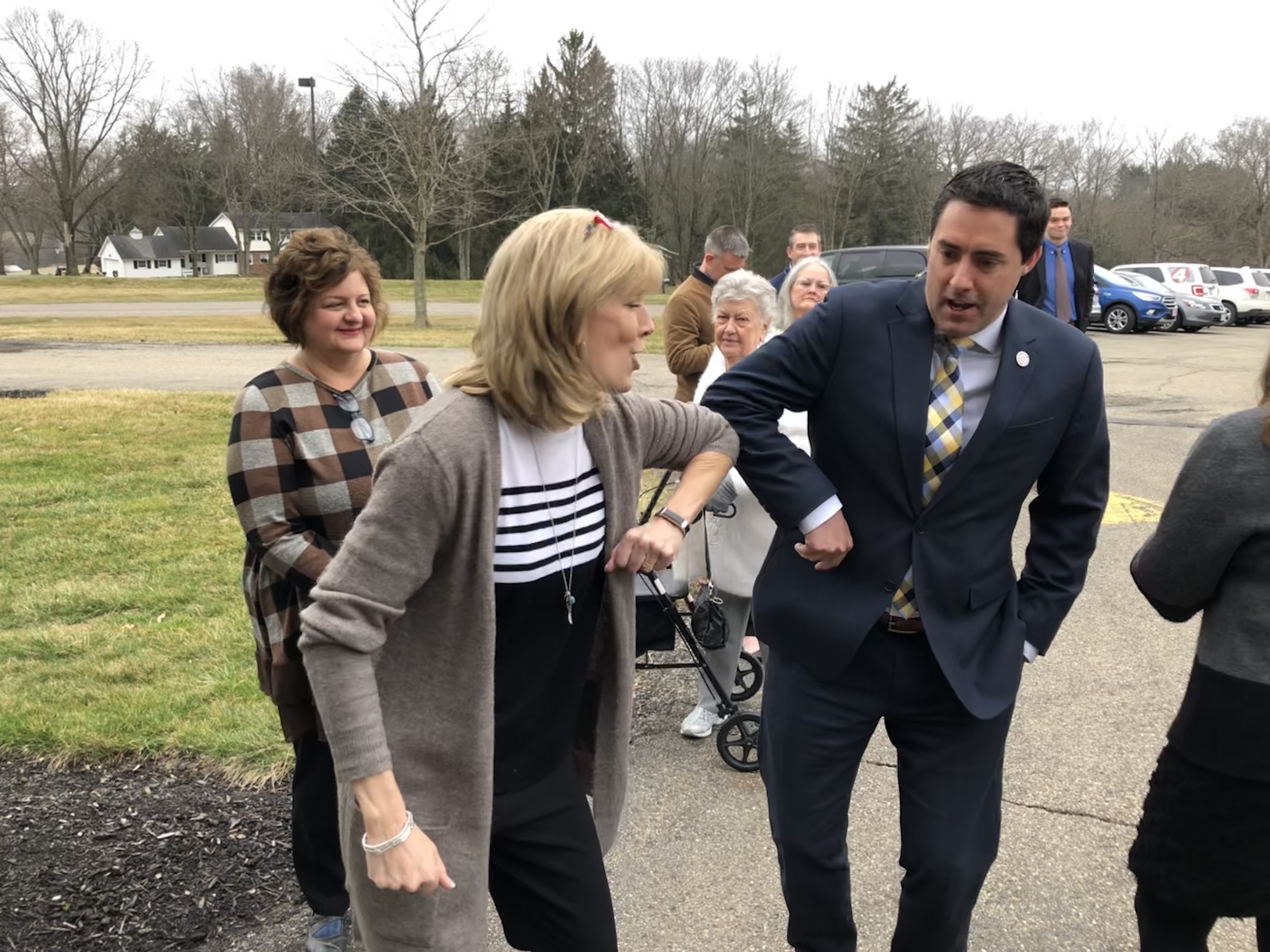 Ohio Secretary of State Frank LaRose, right, elbow bumps Michele Engelbach, left. Engelbach runs a senior living facility in Mt. Vernon, Ohio, which is no longer a voting location because of the coronavirus outbreak. (Ohio Public Radio)