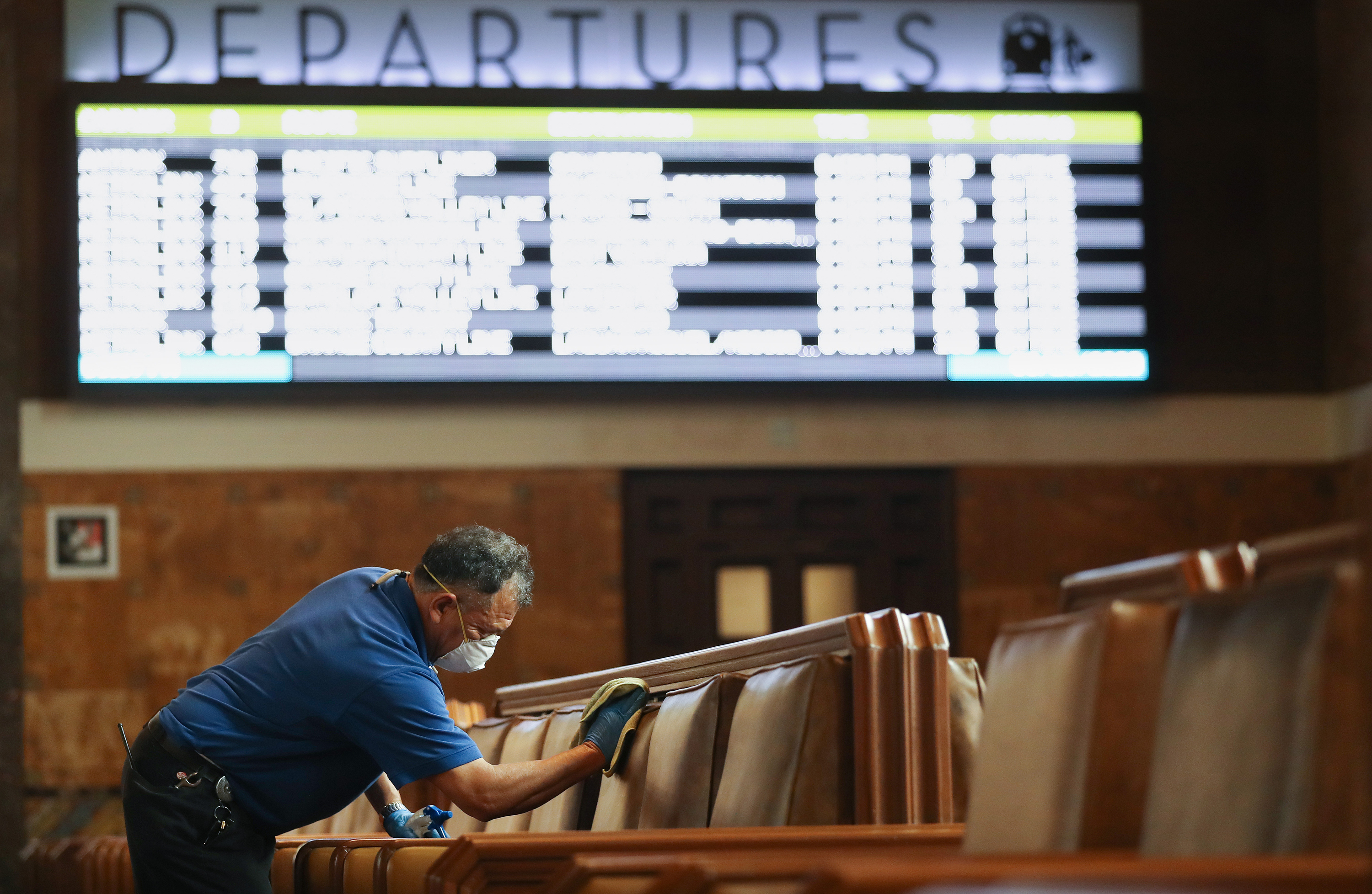 A member of the custodial staff at Los Angeles' Union Station, taking extra care in the waiting area — all part of enhanced cleaning efforts at major transit hubs in response to COVID-19. (Getty Images)
