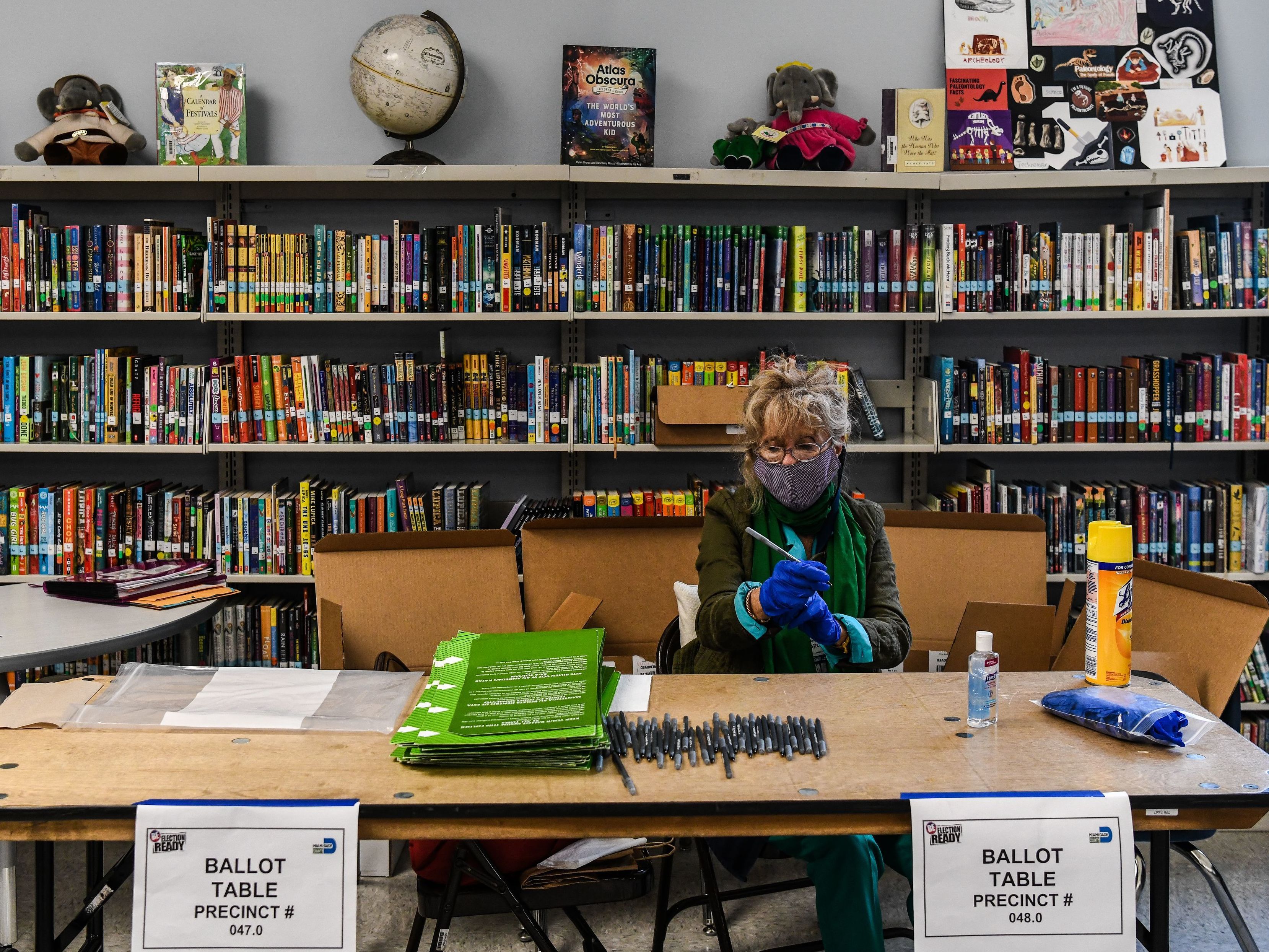 An election worker wears protective gloves during the Florida primary election at South Pointe Elementary School in Miami, on Tuesday. (AFP via Getty Images)
