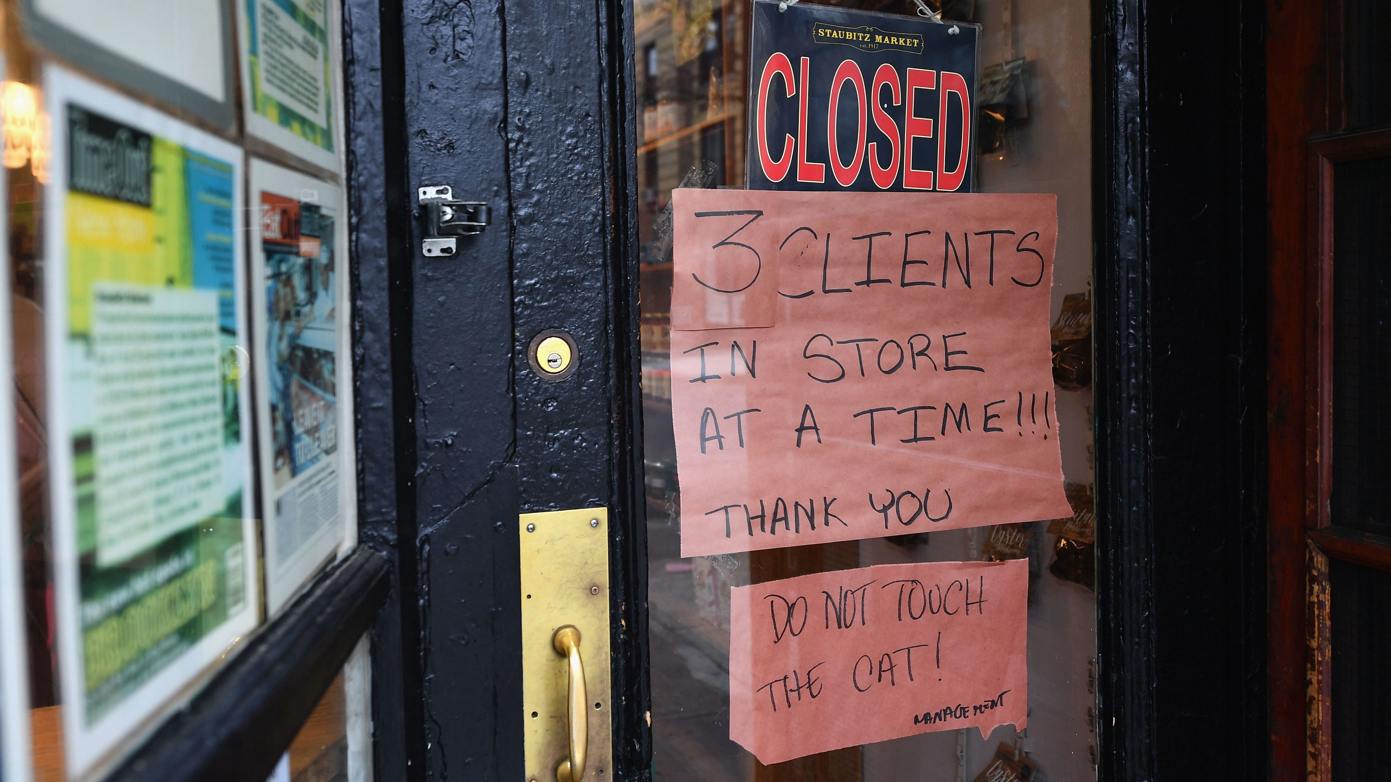 A butcher shop in the Brooklyn borough of New York shows a "Closed" sign, limiting customers to three at a time. Gov. Andrew Cuomo is ordering all non-essential businesses to close, in an escalation of the state