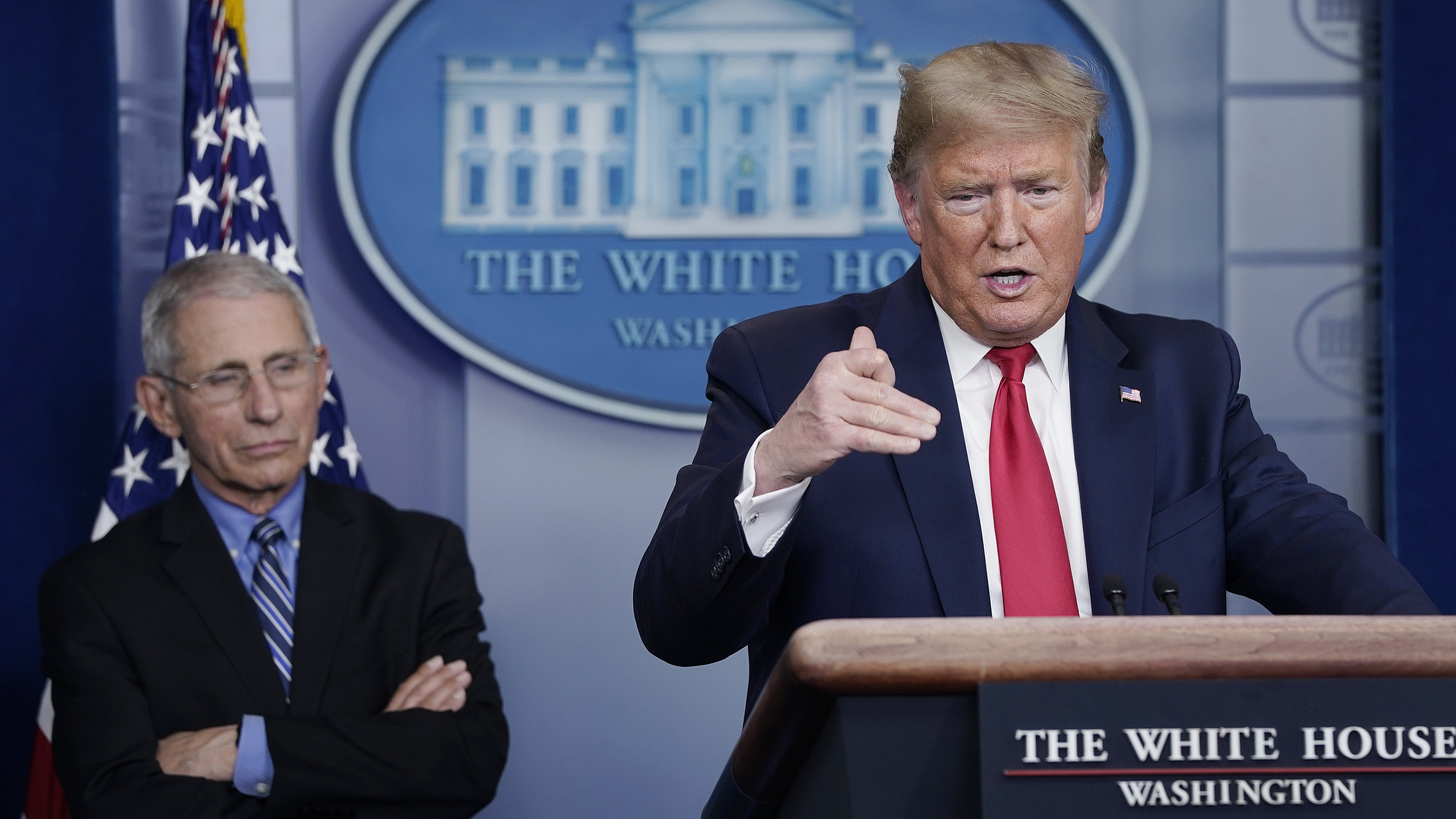 President Trump speaks while Dr. Anthony Fauci listens during Tuesday's briefing on the coronavirus pandemic. (Getty Images)