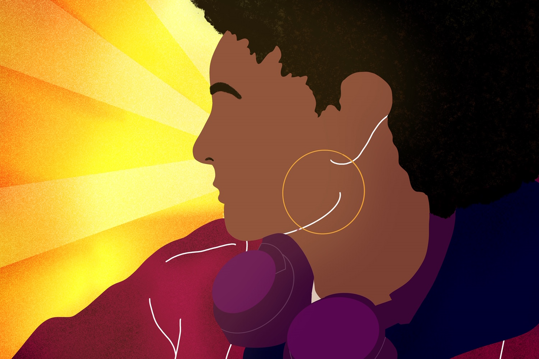 a black woman looking to the side with headphones in
