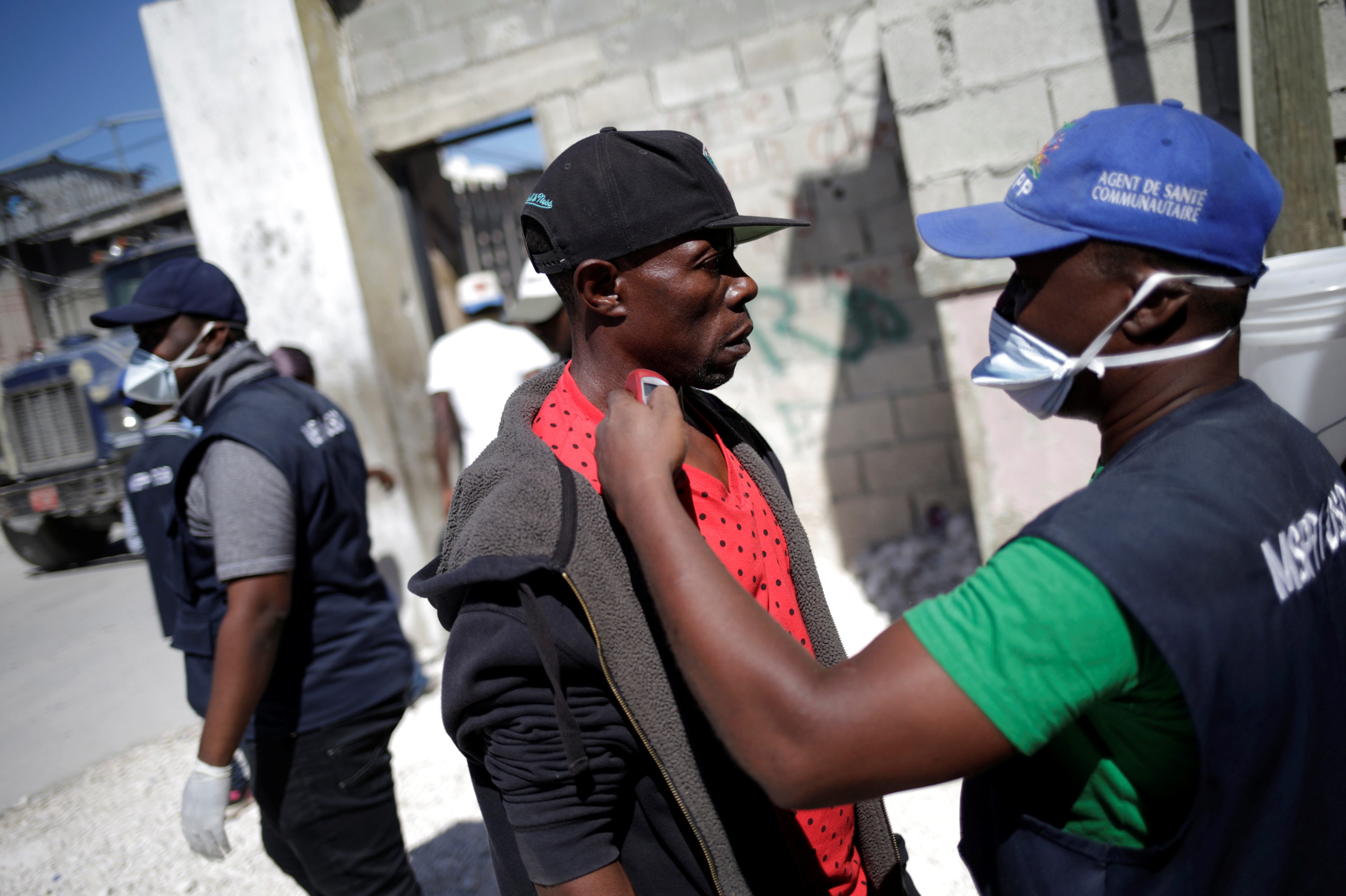 A worker with Haiti's Ministry of Public Health and Population checks the temperature of a Haitian man coming from the Dominican Republic on March 5. (Reuters)