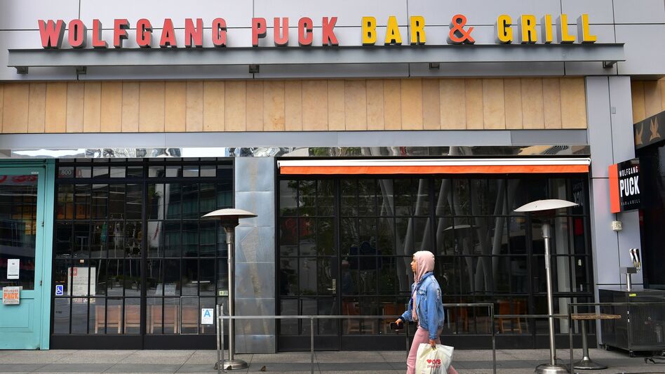 A pedestrian walks past a closed Wolfgang Puck Bar & Grill restaurant in Los Angeles. President Trump has suggested changing tax deductibility law as a way of helping the restaurant industry. (Frederic J. Brown/AFP via Getty Images)
