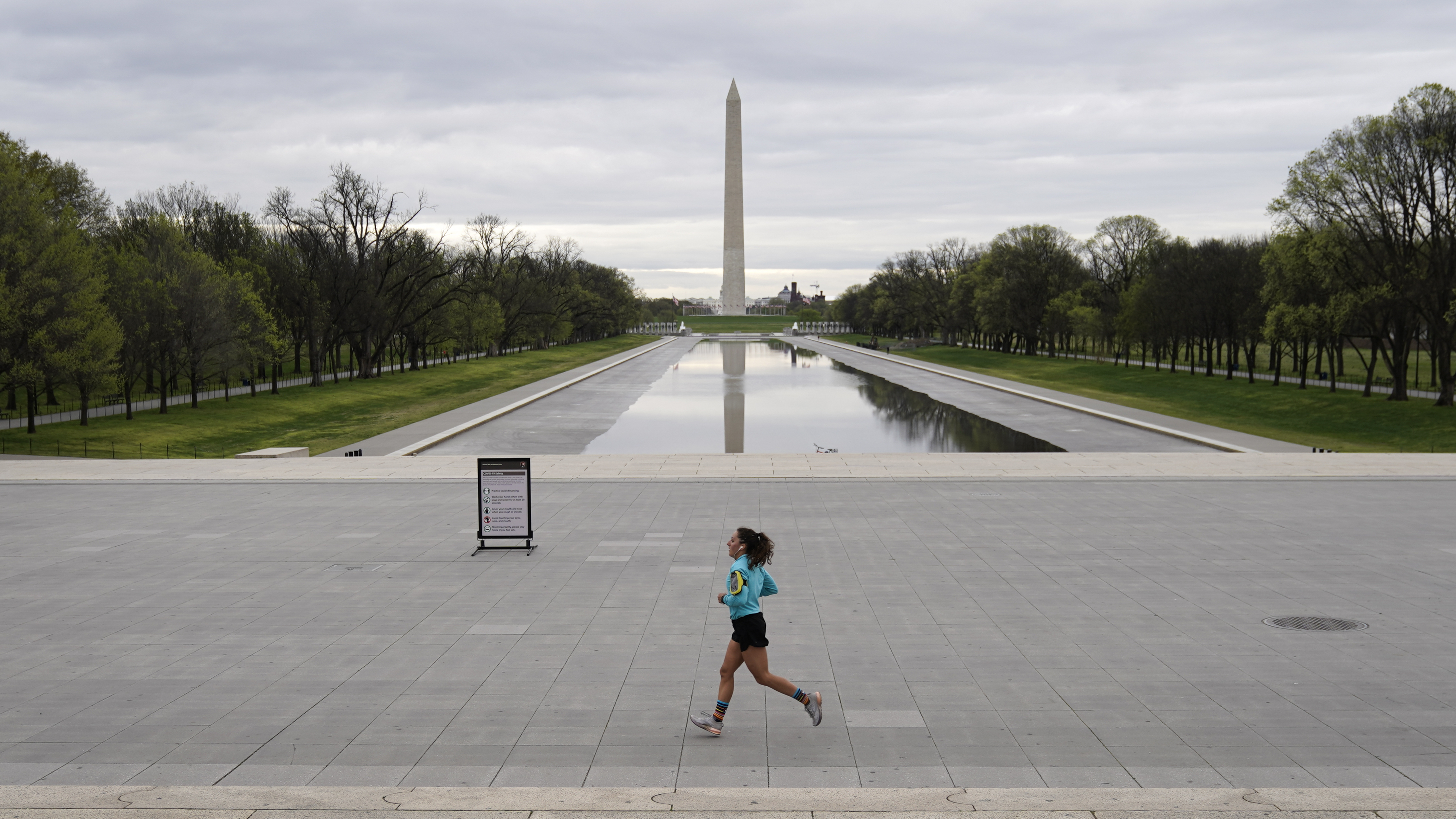 A woman jogs along a mostly empty National Mall on March 31, 2020 in Washington, D.C. To prevent the spread of the coronavirus, Virginia, Maryland and the District of Columbia all announced stay-at-home orders this week, which strongly discourage residents from leaving home unless absolutely necessary or essential. (Getty Images)
