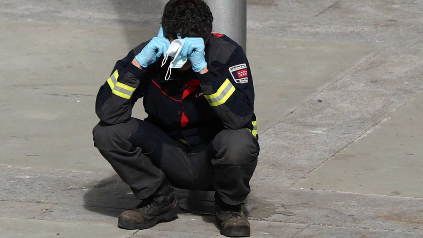 A firefighter takes a moment to rest outside a temporary hospital in a conference center in Madrid, Spain, that was set up as an overflow area for COVID-19 patients. More than a million coronavirus cases are now reported worldwide, putting intense pressure on health and emergency workers.