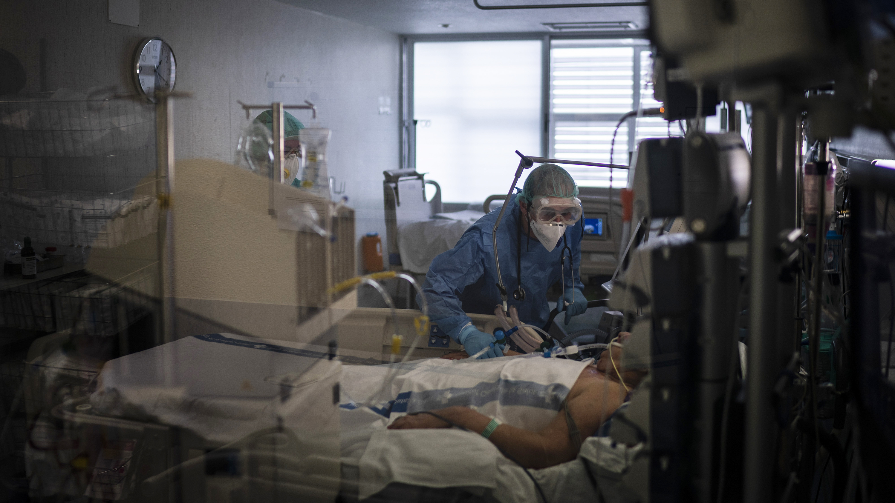 Health care workers assist a COVID-19 patient in Spain. Some evidence from Europe and China suggests an overzealous immune response may be contributing to the severe illness in some patients.