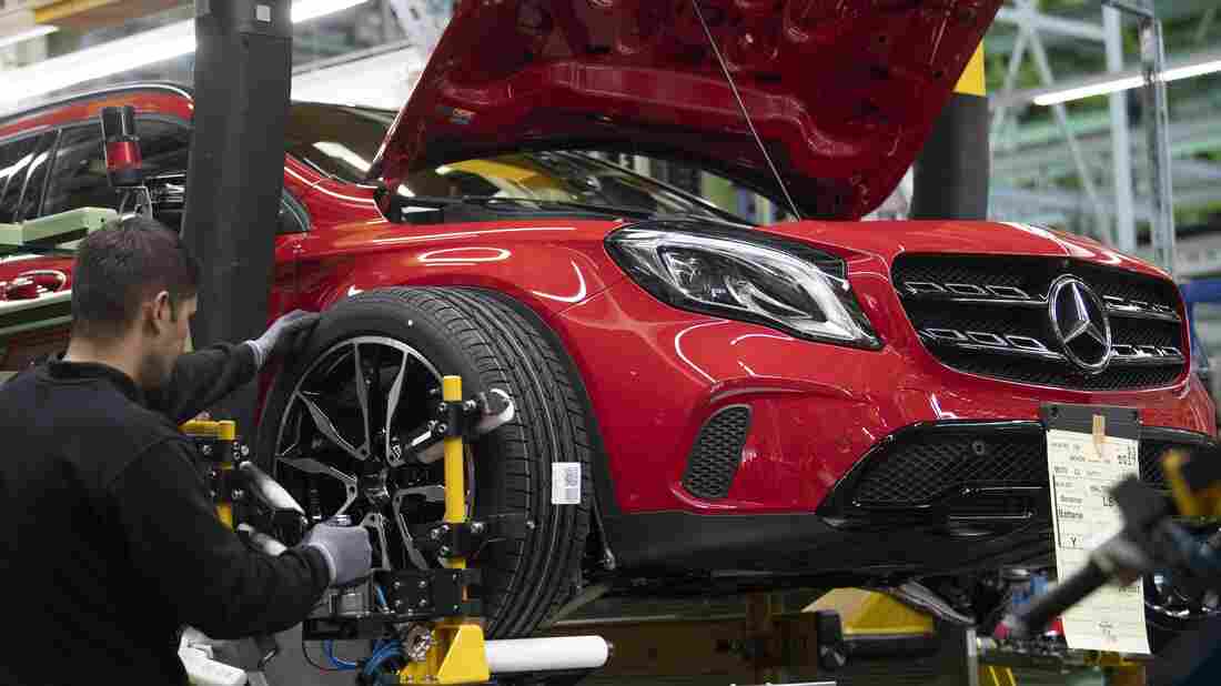 An employee mounts a wheel on a Mercedes-Benz A Class on the assembly line at the Daimler AG factory in Rastatt, southwestern Germany.