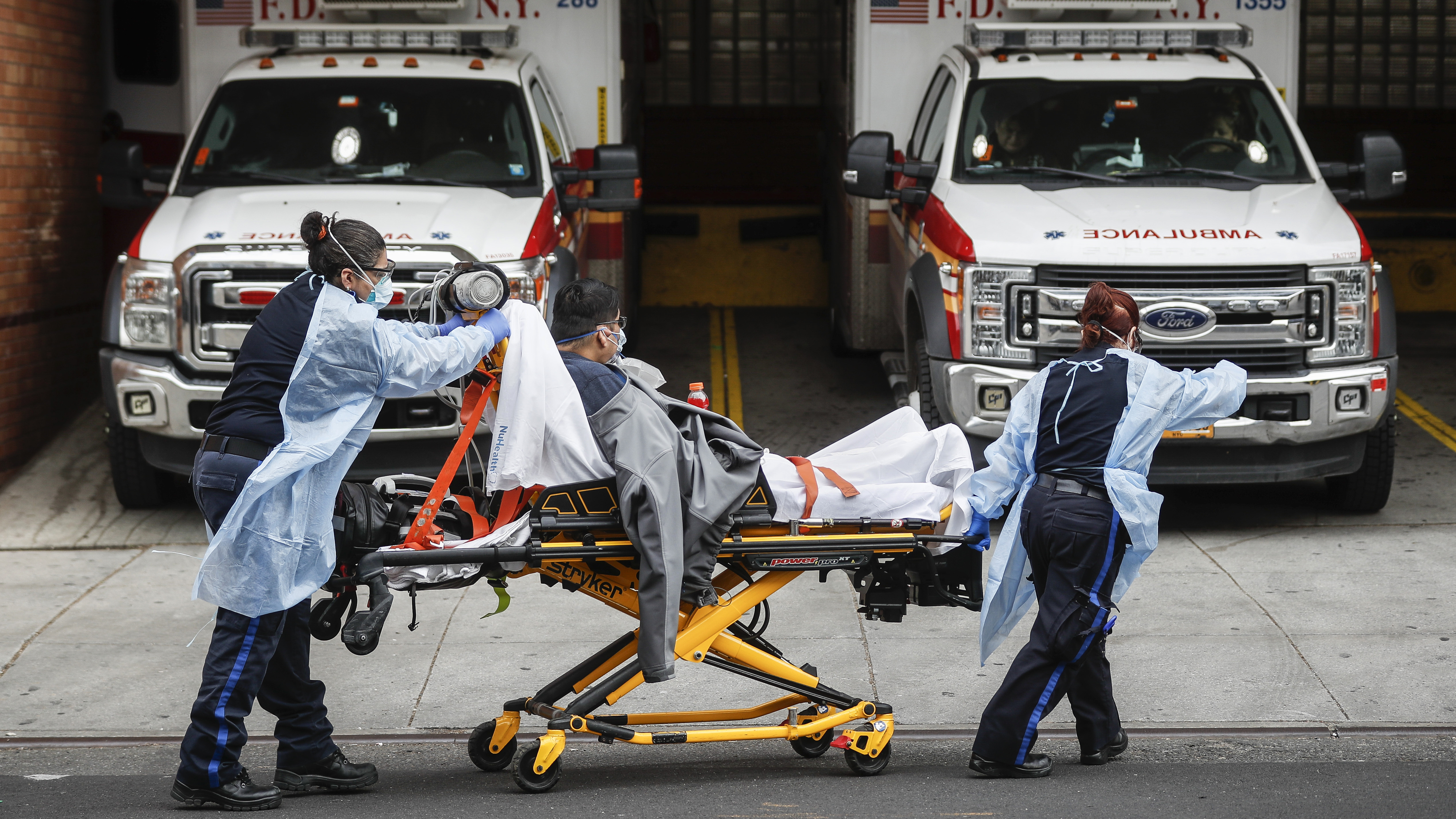 Patients are brought into Wyckoff Heights Medical Center by staff wearing personal protective gear due to COVID-19 concerns on Tuesday in the Brooklyn borough of New York.