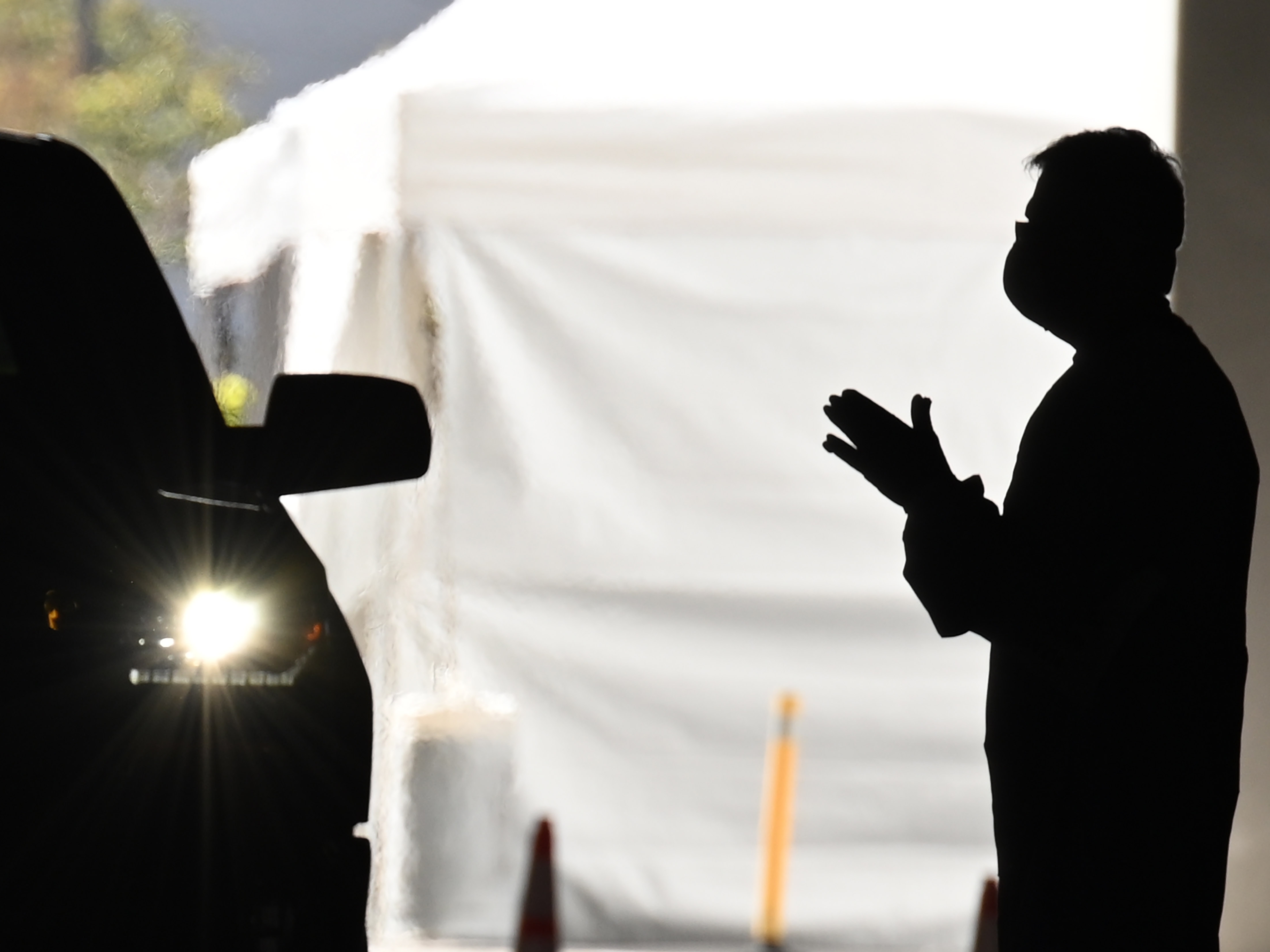 A health care worker instructs people arriving in their cars to be tested for COVID-19 at a new coronavirus drive through testing site in Redondo Beach, Calif. (AFP via Getty Images)