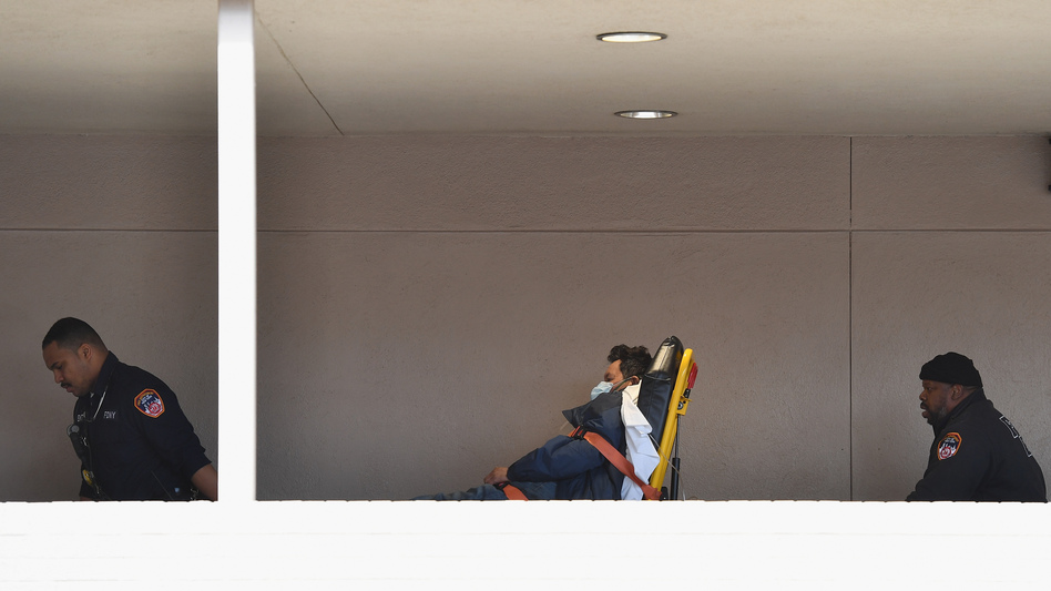 Medical staff move a patient into the emergency room of a Brooklyn hospital on Tuesday. Preliminary data released Wednesday by New York City's health authorities revealed a disproportionately high impact on some of the city's communities of color. (Angela Weiss/AFP via Getty Images)