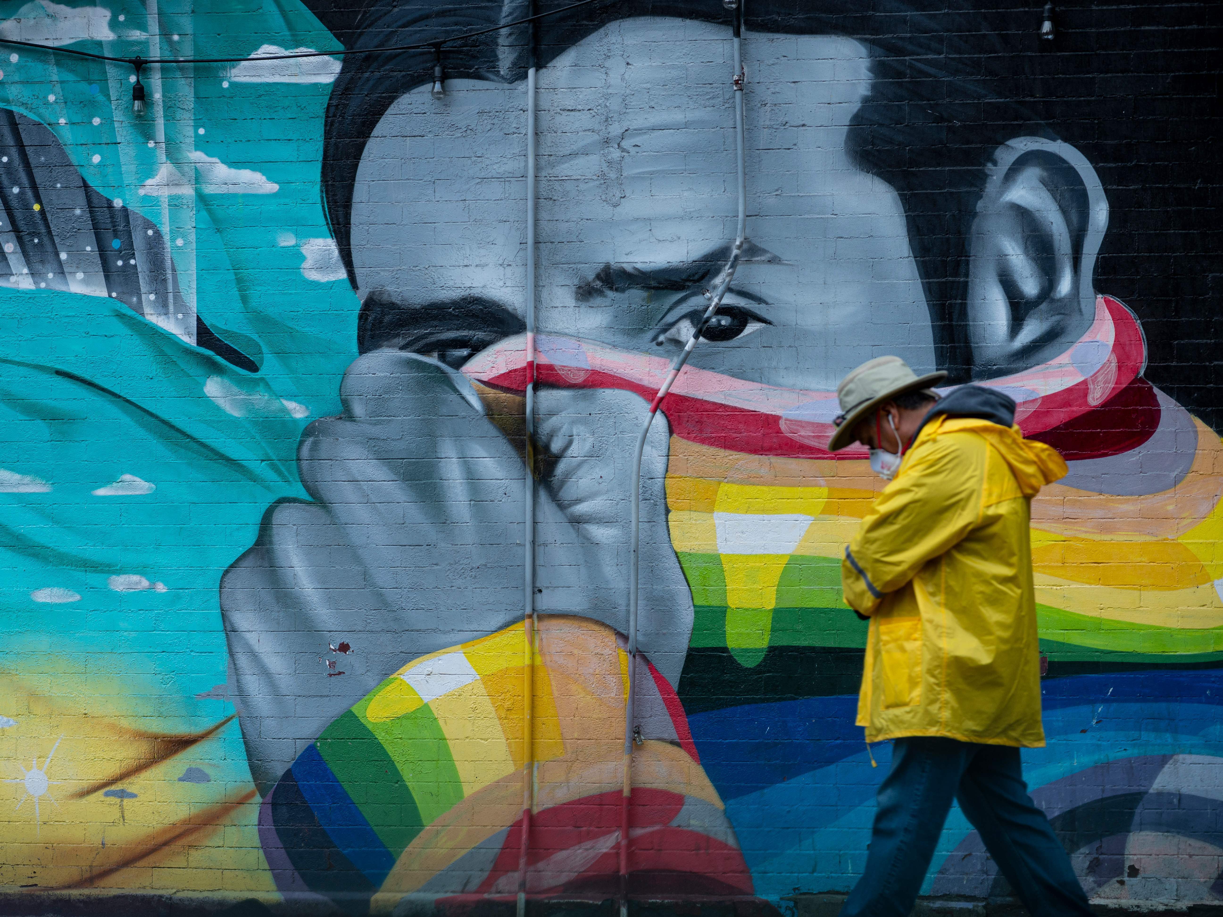 Health experts say they're not yet sure about the level of immunity people may have after recovering from COVID-19. Here, a man wears a protective mask as he passes a mural in New York City, where the COVID-19 death toll has passed 10,000. (AFP via Getty Images)