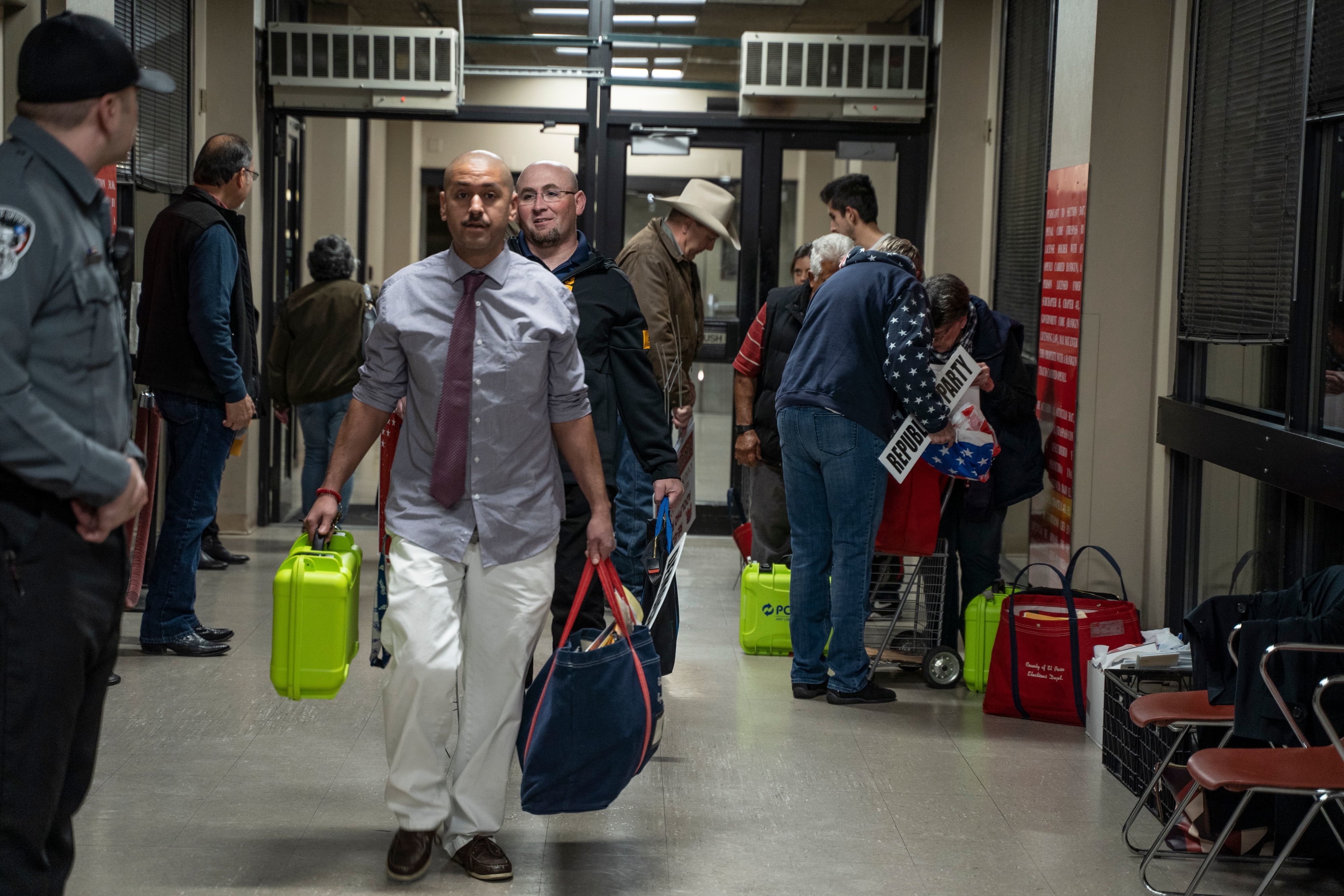 Election officials carrying equipment during last month's presidential primary in El Paso. A Texas judge says he will allow all voters to apply for absentee ballots in light of the coronavirus pandemic. The state typically makes it difficult to cast such ballots. (AFP via Getty Images)