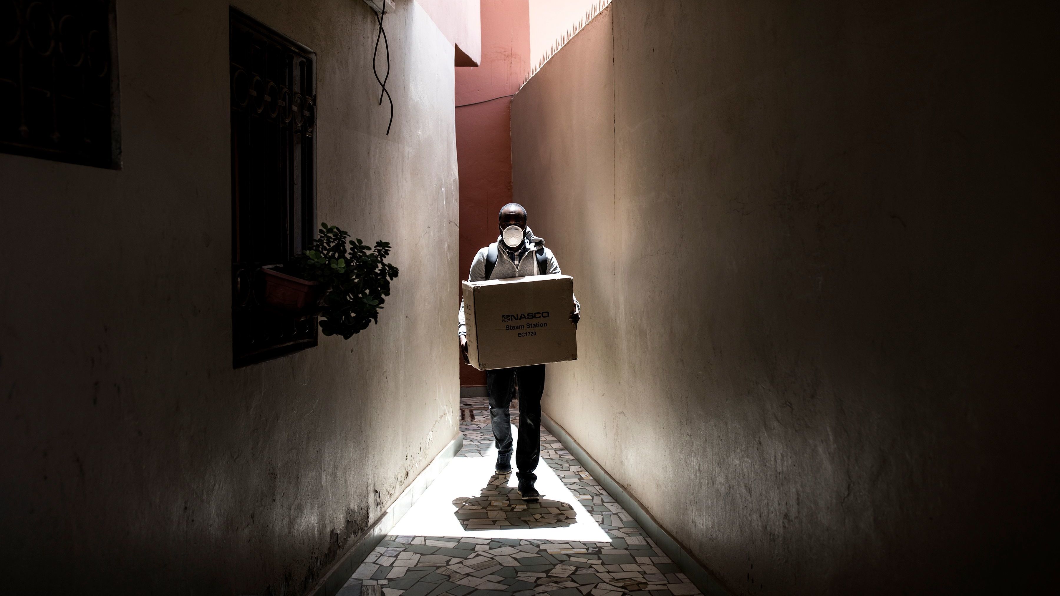 A man carries a box of protective masks to emergency workers Thursday in Dakar, the capital of Senegal. The West African country has seen relatively few confirmed cases of the coronavirus to this point — but global health officials fear that won