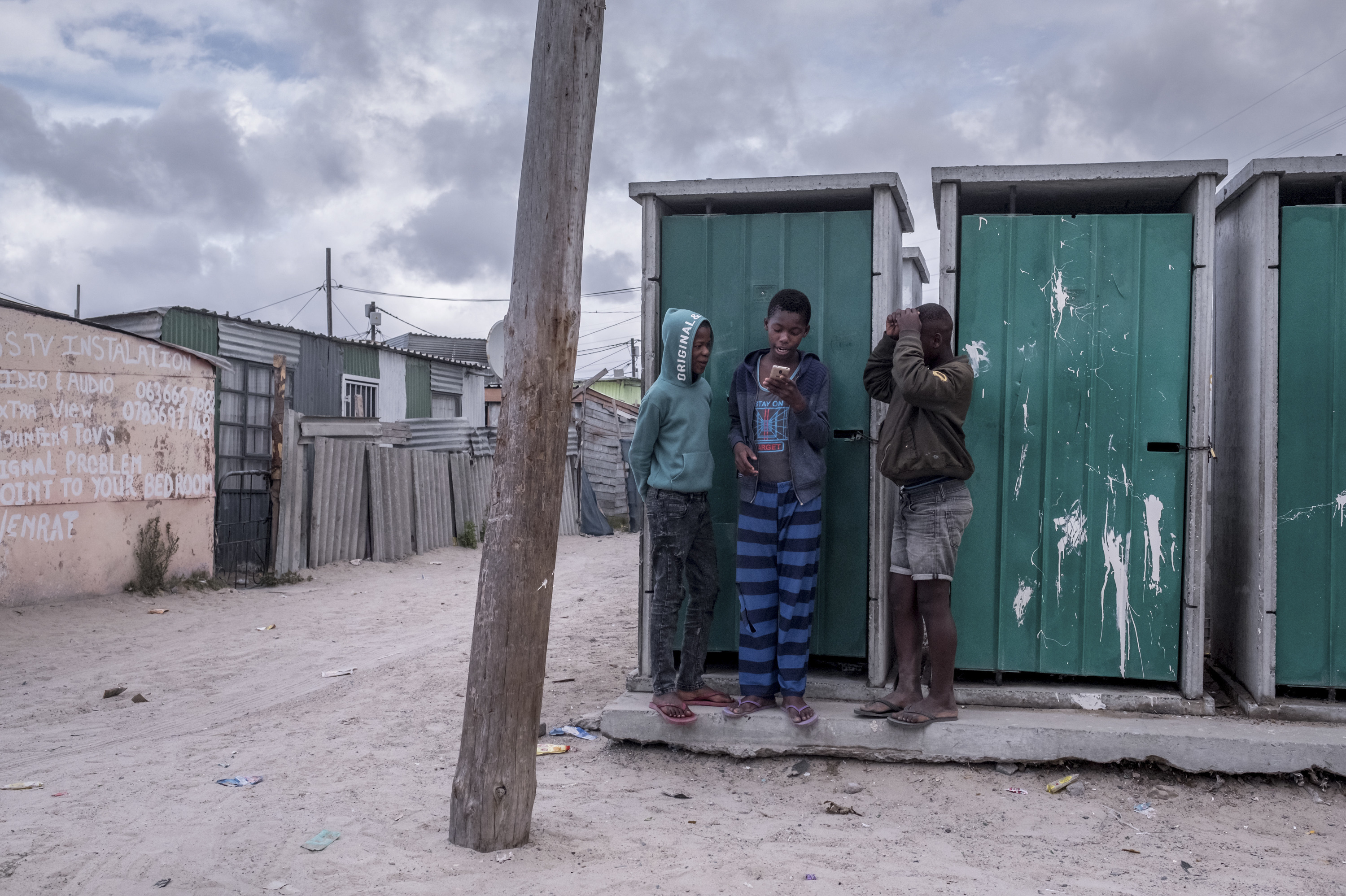 PHOTOS: Lockdown In The World's Most Unequal Country 4 Boys gather at the communal toilets to get a cellphone signal in the township of Khayelitsha, Cape Town.