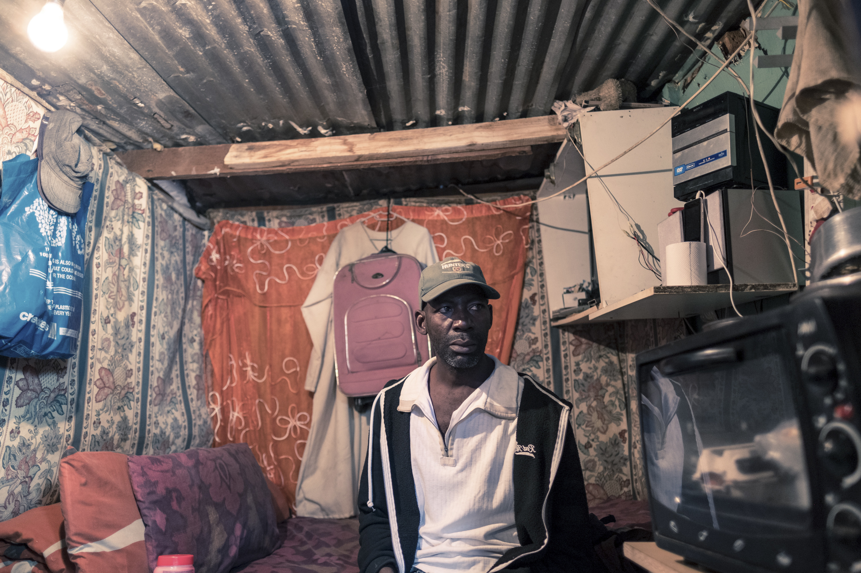 PHOTOS: Lockdown In The World's Most Unequal Country 5 Ishmae Uchani, 47, in his one-room home in the township of Masiphumelele in Cape Town. Uchani shares his house, which measures approximately 6 feet by 10 feet, with his wife and two children. He says the government's orders to stay at home during the coronavirus lockdown are unworkable. Uchani was a day laborer in the construction industry before the lockdown and has now lost his income.