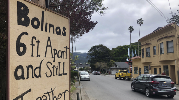 A sign about being 6 feet apart is posted along the main road through Bolinas, Calif. Residents are undergoing testing as part of a coronavirus study.