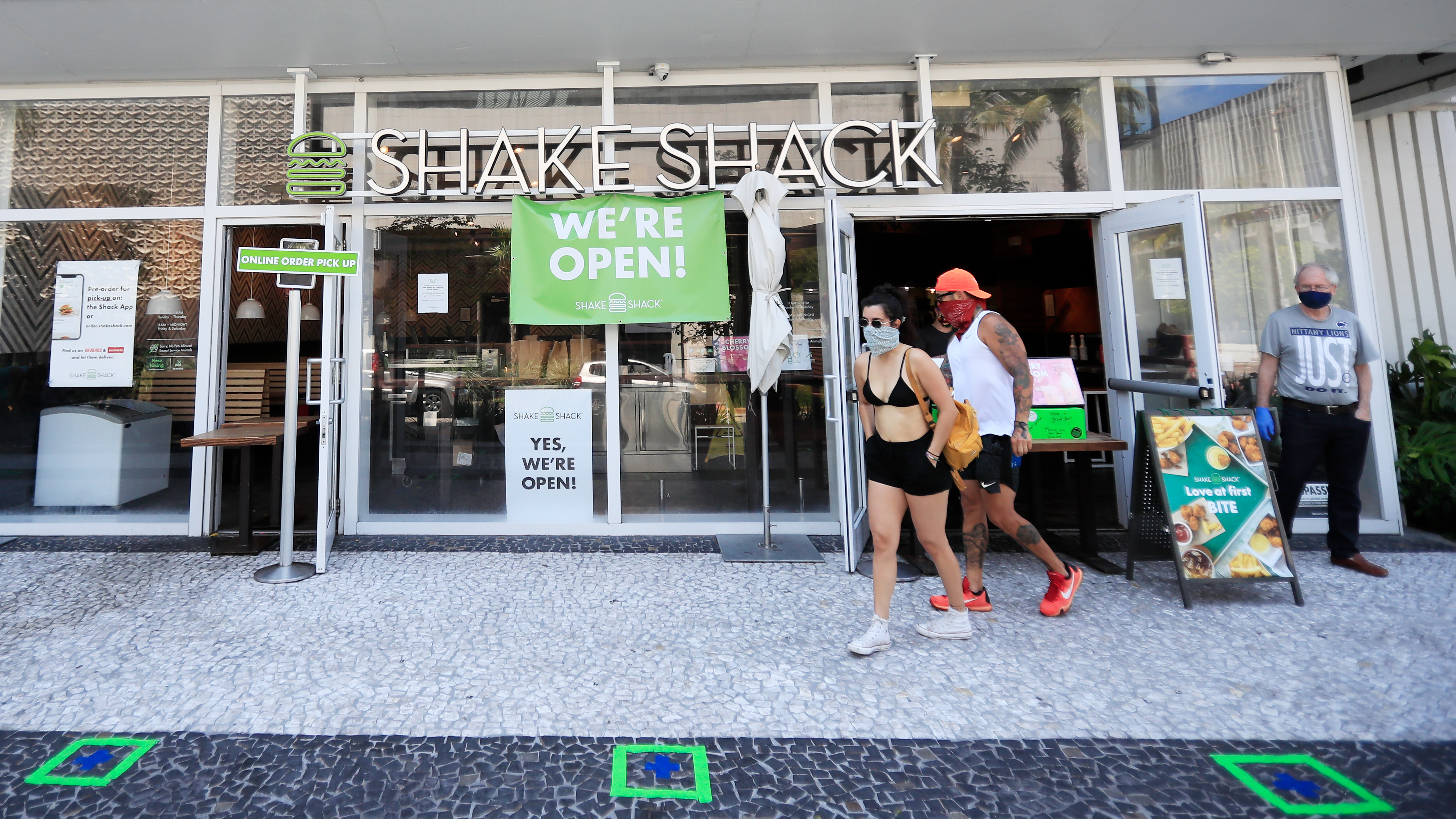 Shake Shack is returning a $10 million loan to the Small Business Administration, saying the money should go to restaurants that need it more. Here, customers wait for to-go orders outside a Shake Shack in Miami Beach, Fla. (Getty Images)