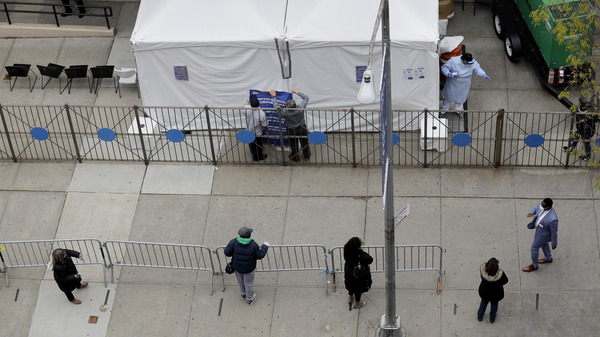 People stand in line as they wait to get tested for COVID-19 at a just opened testing center in the Harlem section of New York on Monday.