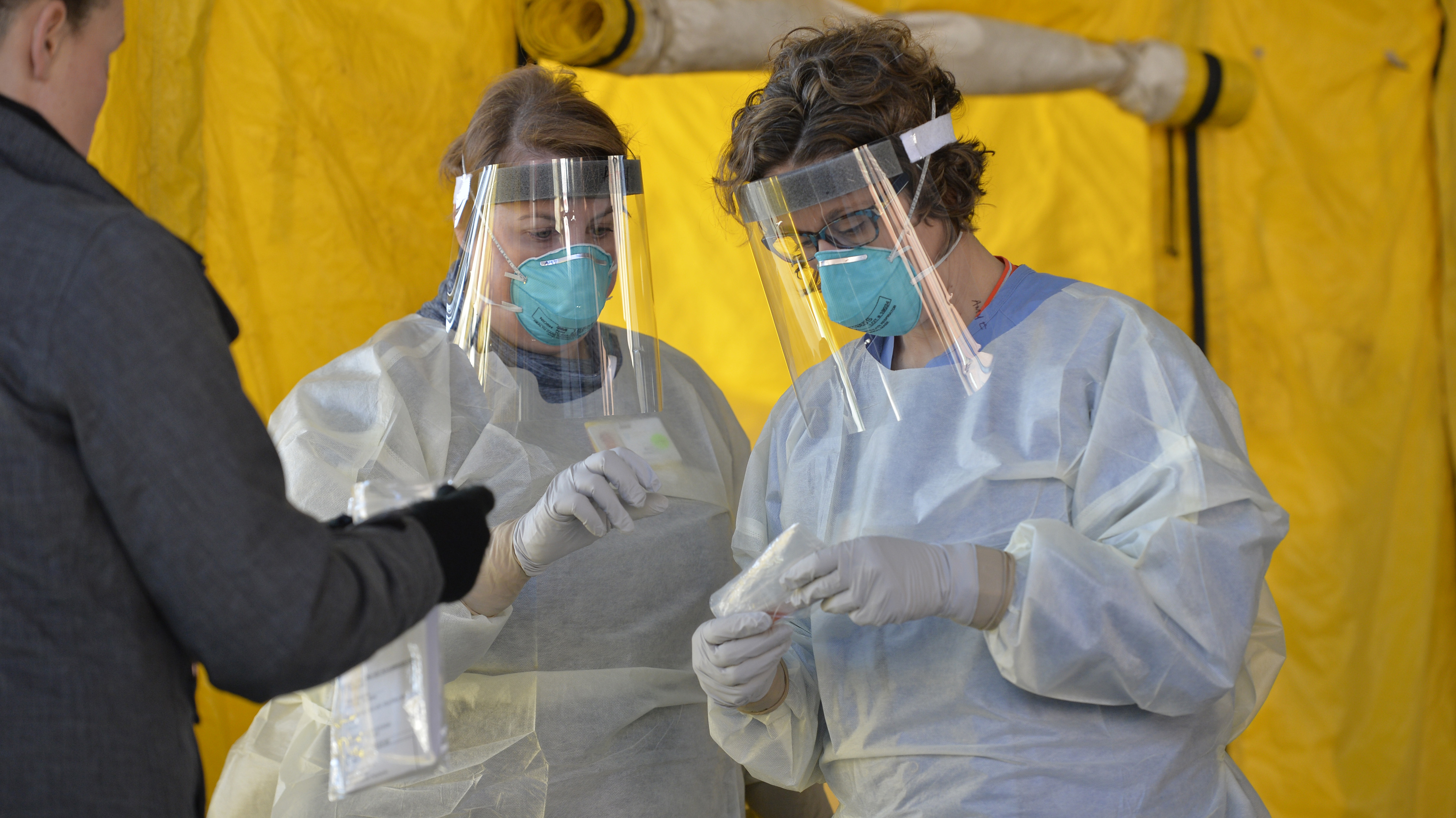Hospital clinicians in Newton, Mass., work with test kits to determine if patients have the coronavirus. New York Gov. Andrew Cuomo says President Trump agreed Tuesday to help his state get more of the supplies needed to expand testing.